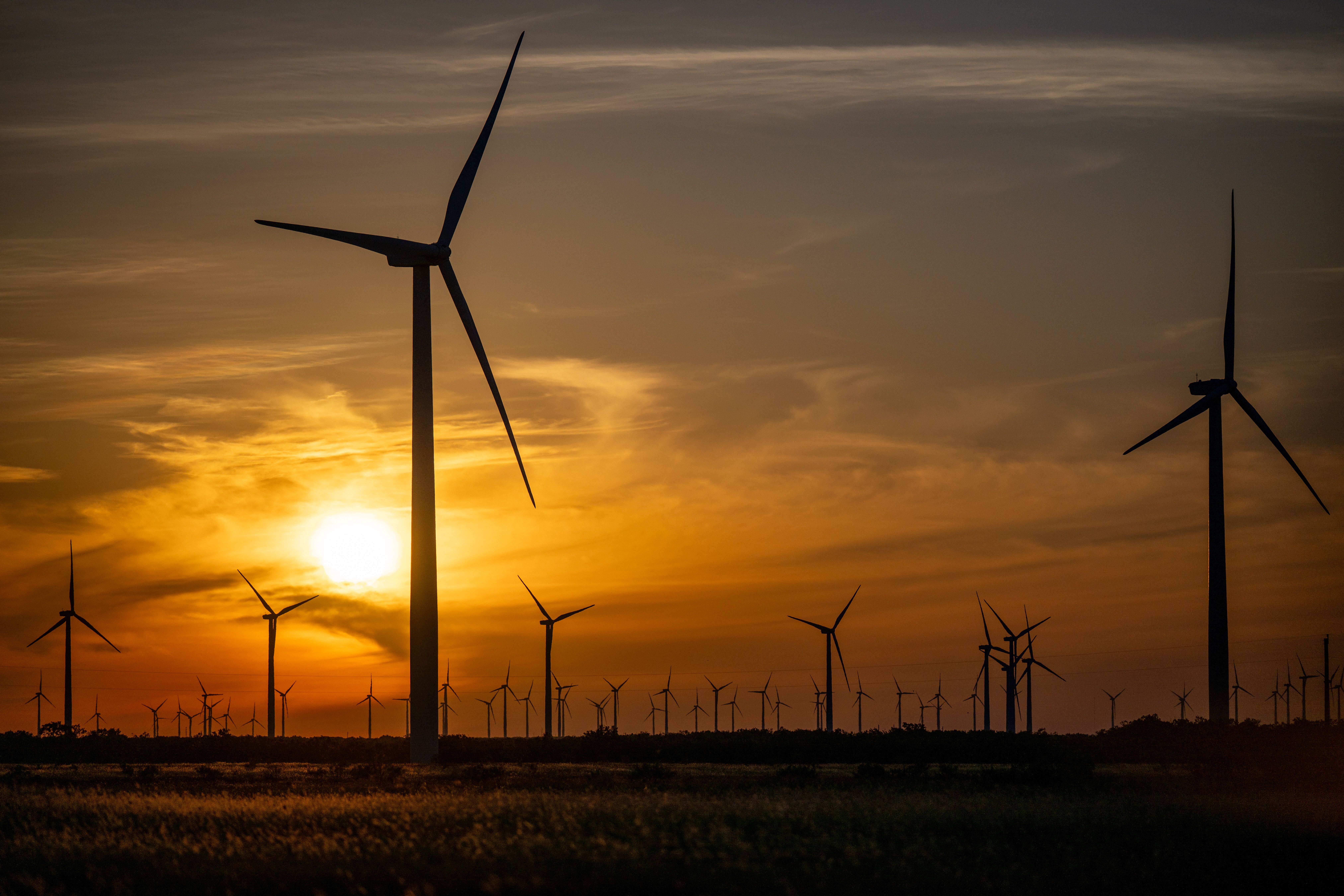 Orange sky behind wind turbines
