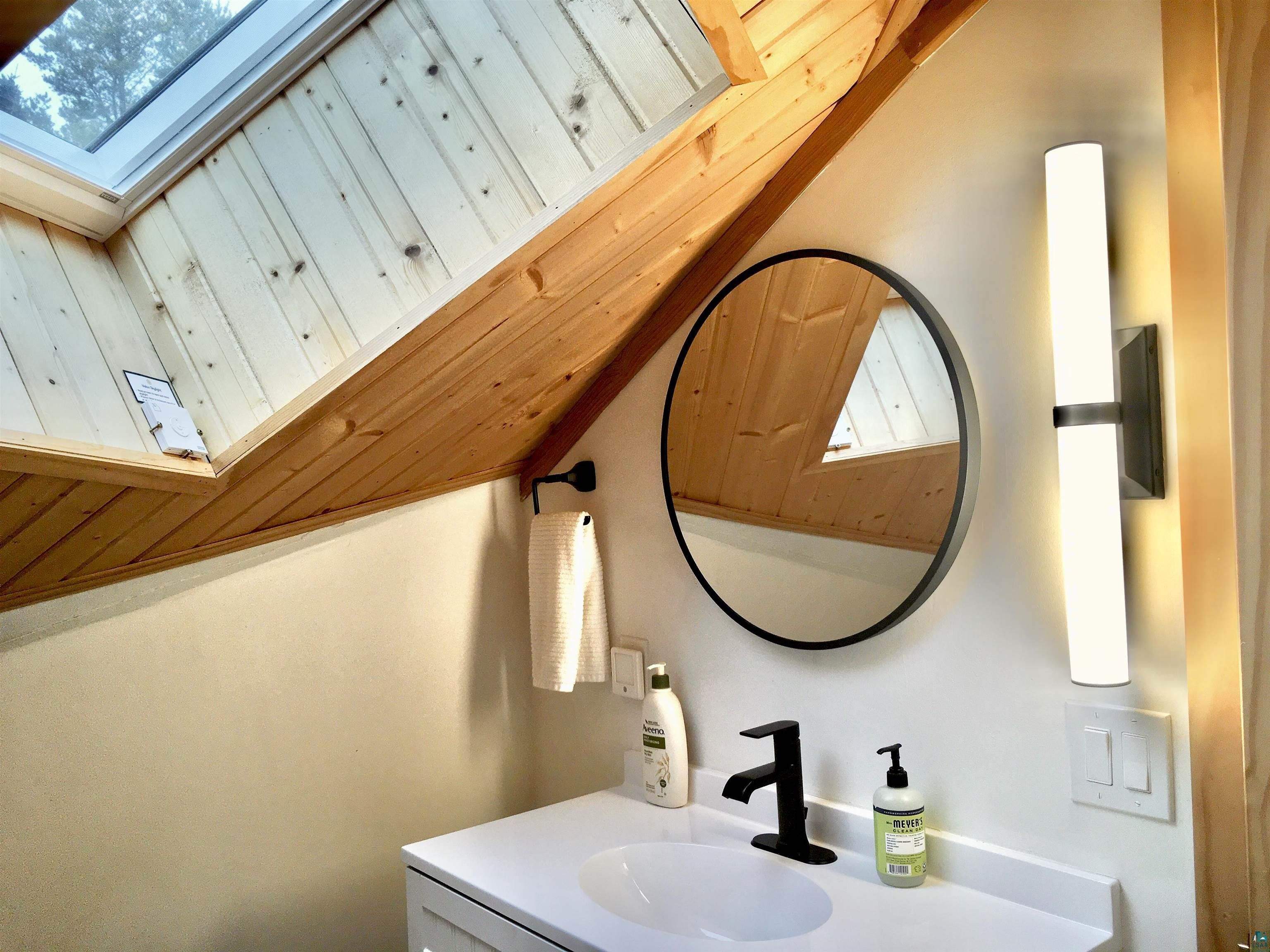 A bathroom in a dome shaped home with large triangle windows.