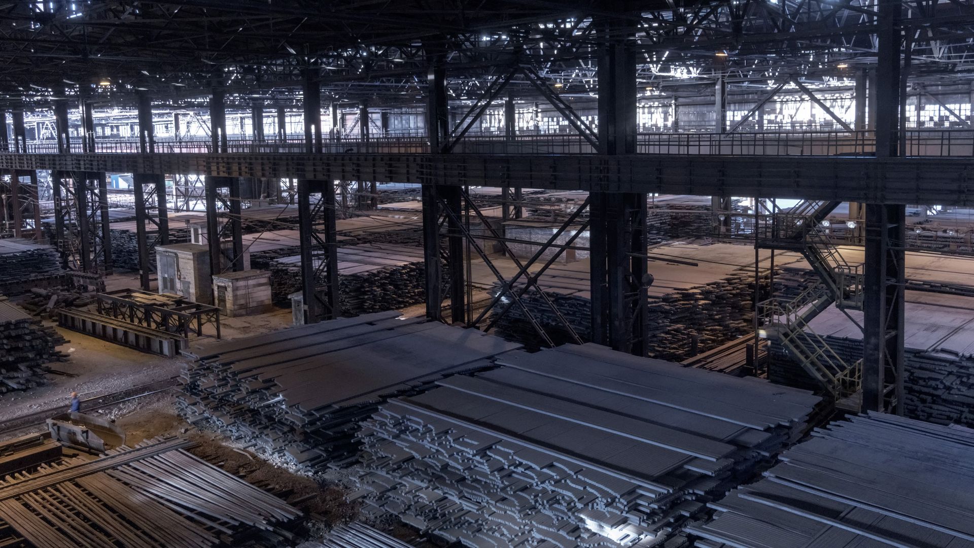 Steel slabs sit stacked in a storage warehouse