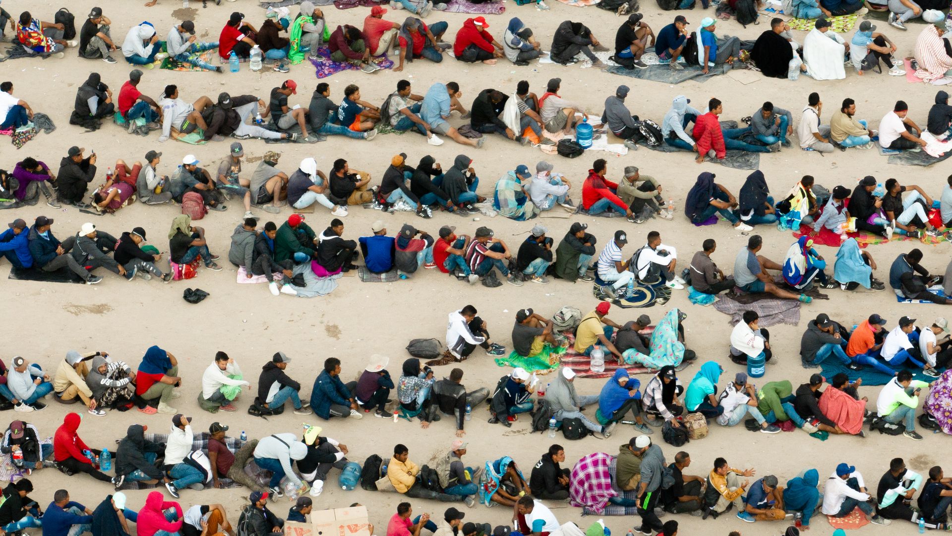 Migrants wait in lines in Mexico, across the border from El Paso, Texas.