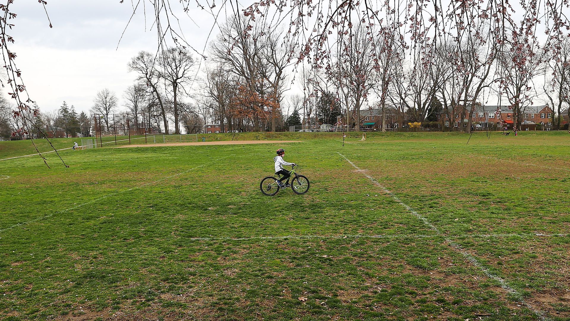 A child riding a bike in an empty field.