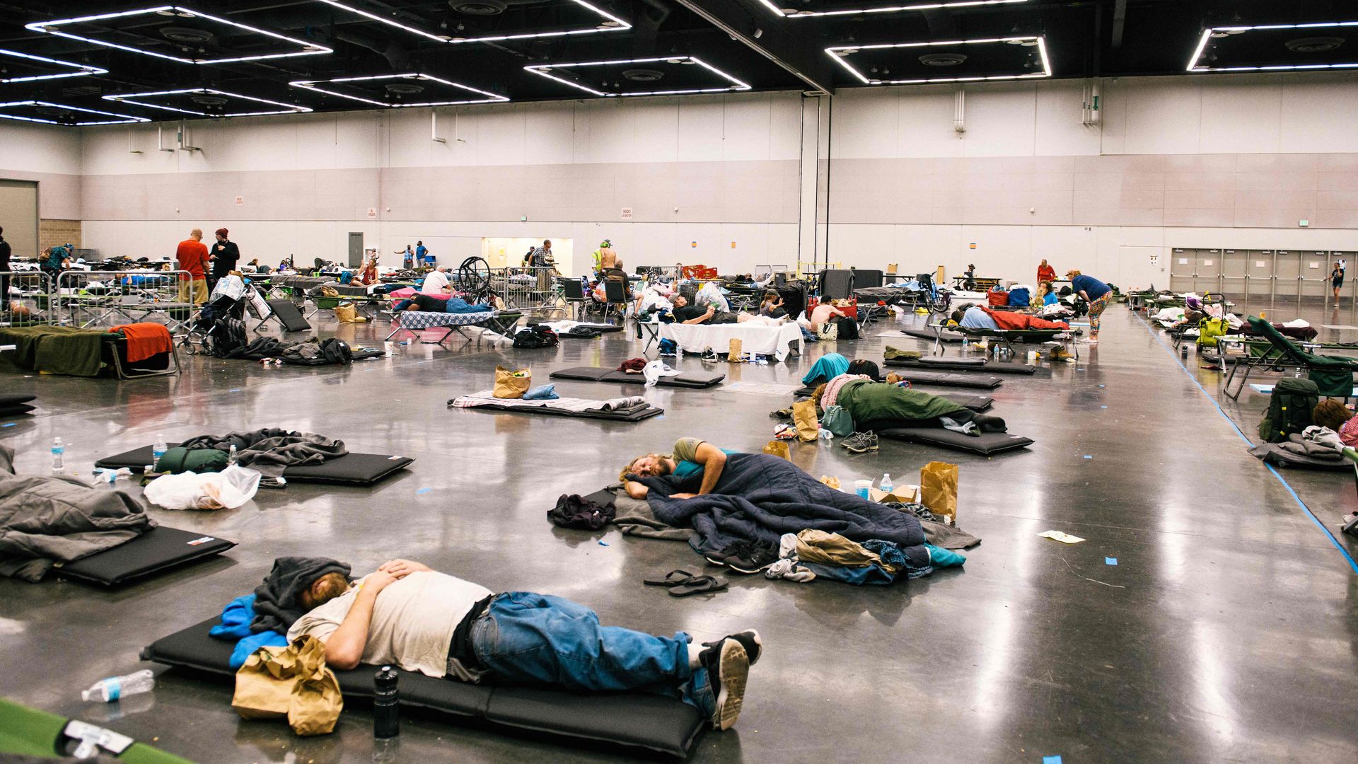 Photo of individuals lying down and spread out across a warehouse