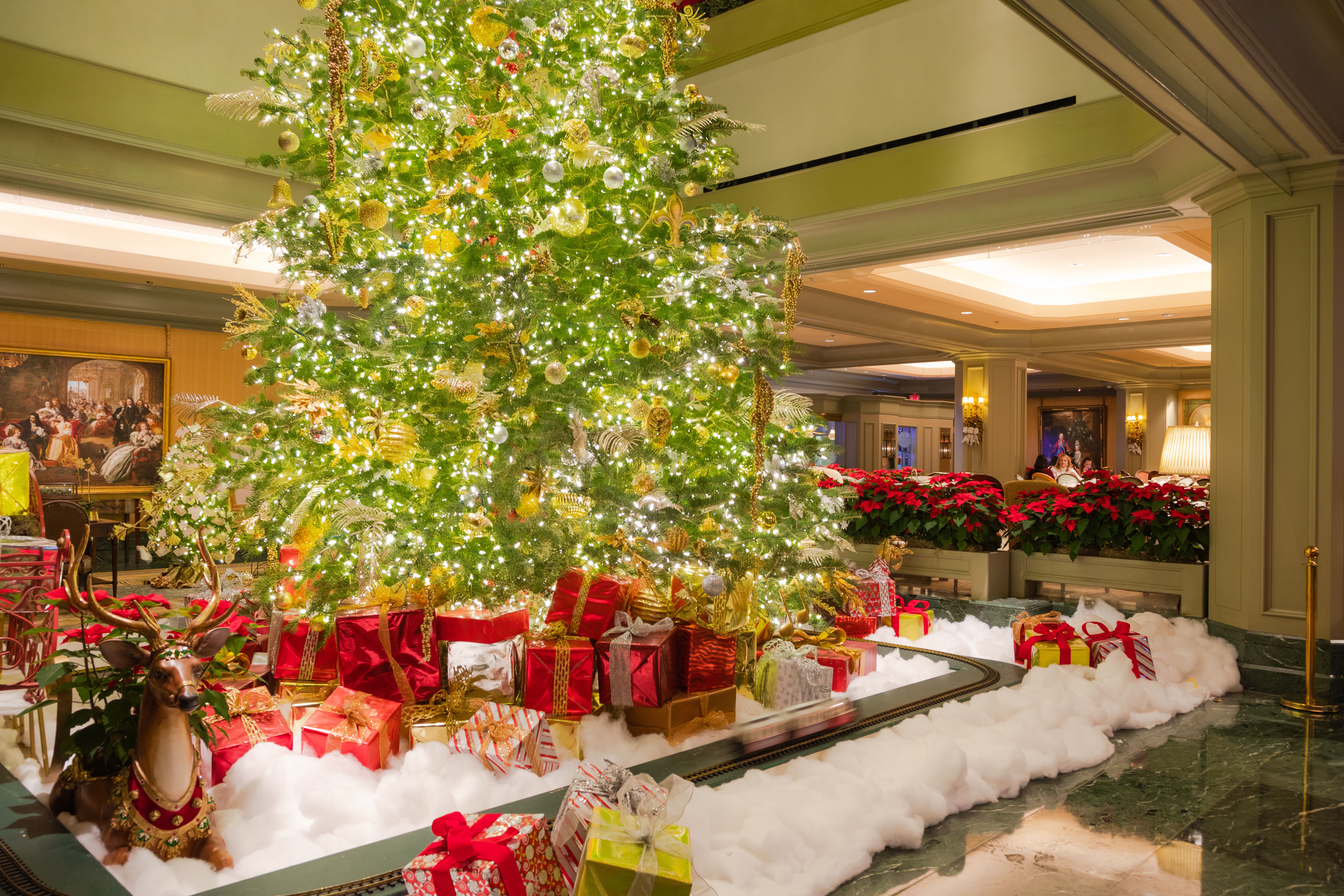 Image shows a Christmas tree in a lobby with wrapped gifts under it.