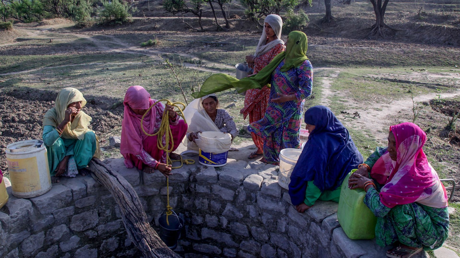 Indian villagers gather near a well running dry to collect drinking water at Padal village of the district of Samba, some 45 km from Jammu, on June 2, 2019.