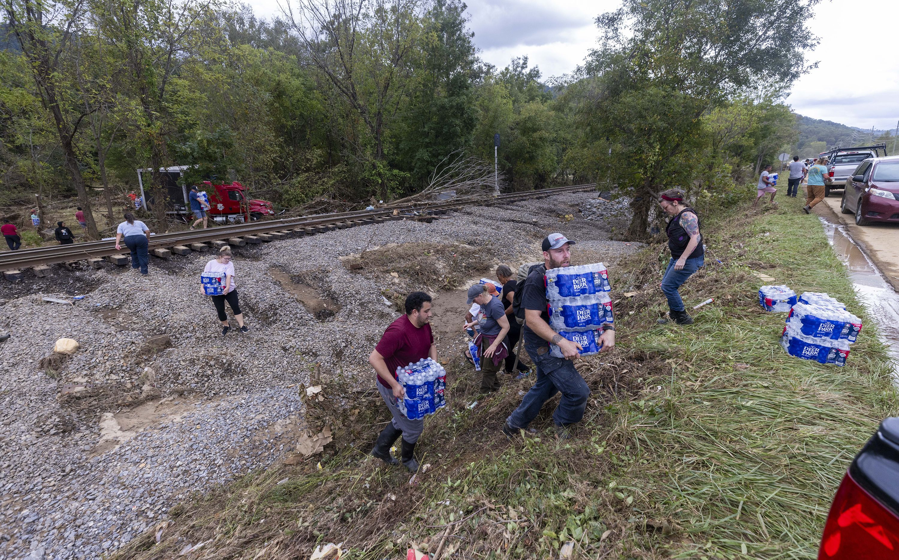 people carrying water to help victims of Tropical Storm Helene