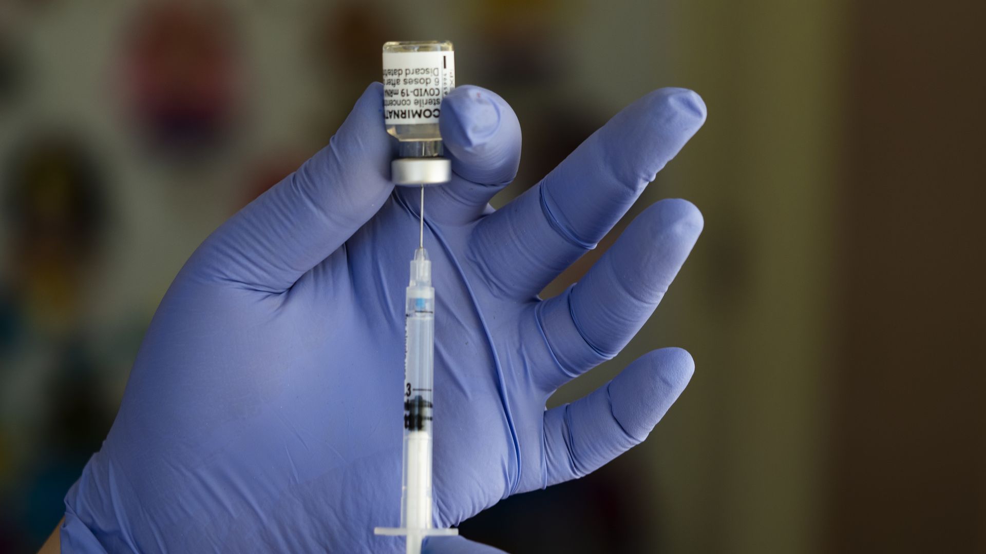 A health worker prepares a syringe with the Pfizer/BioNTech ComirnatyCOVID-19 vaccine.