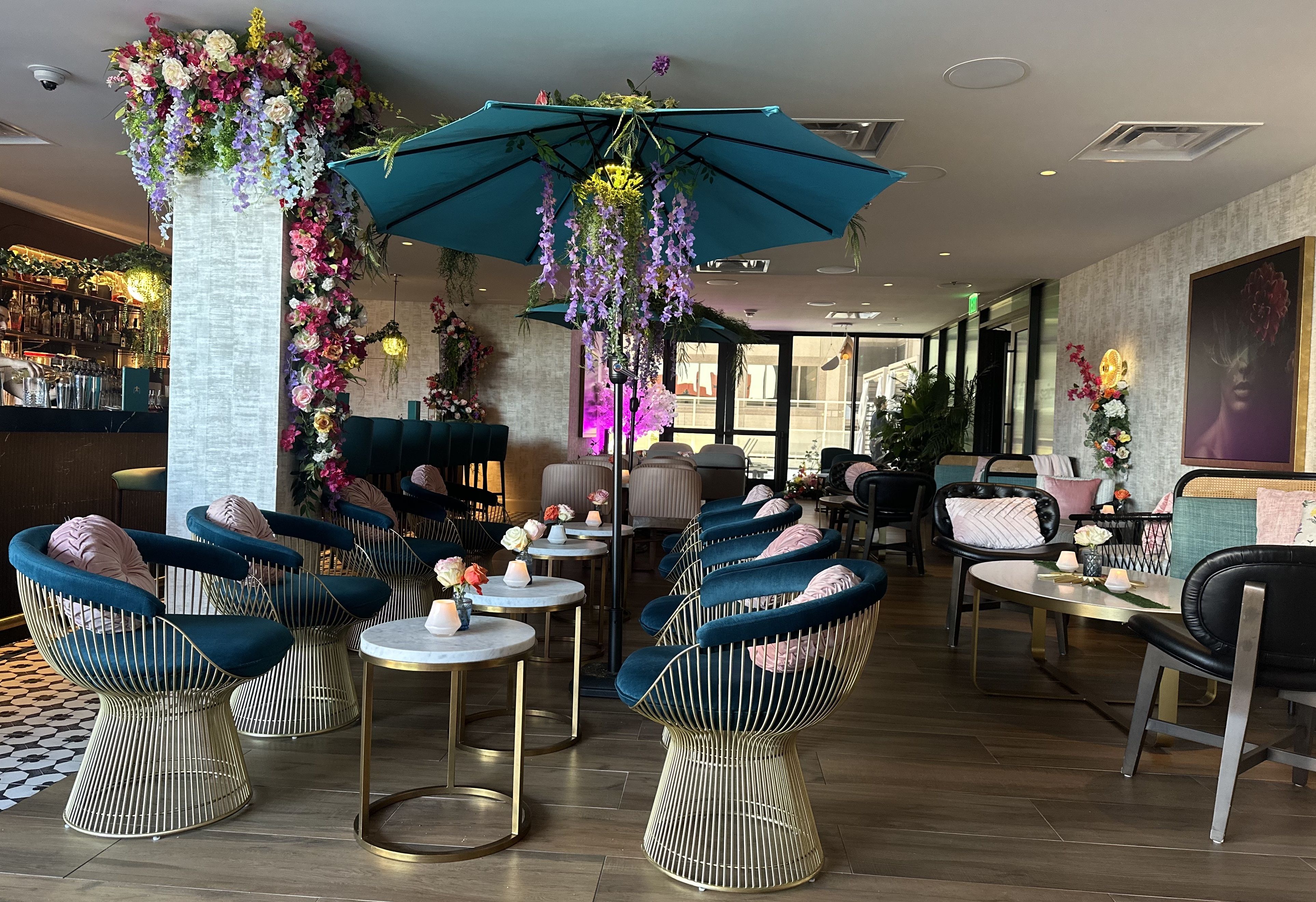 A bar with indoor patio furniture and plenty of floral decor.