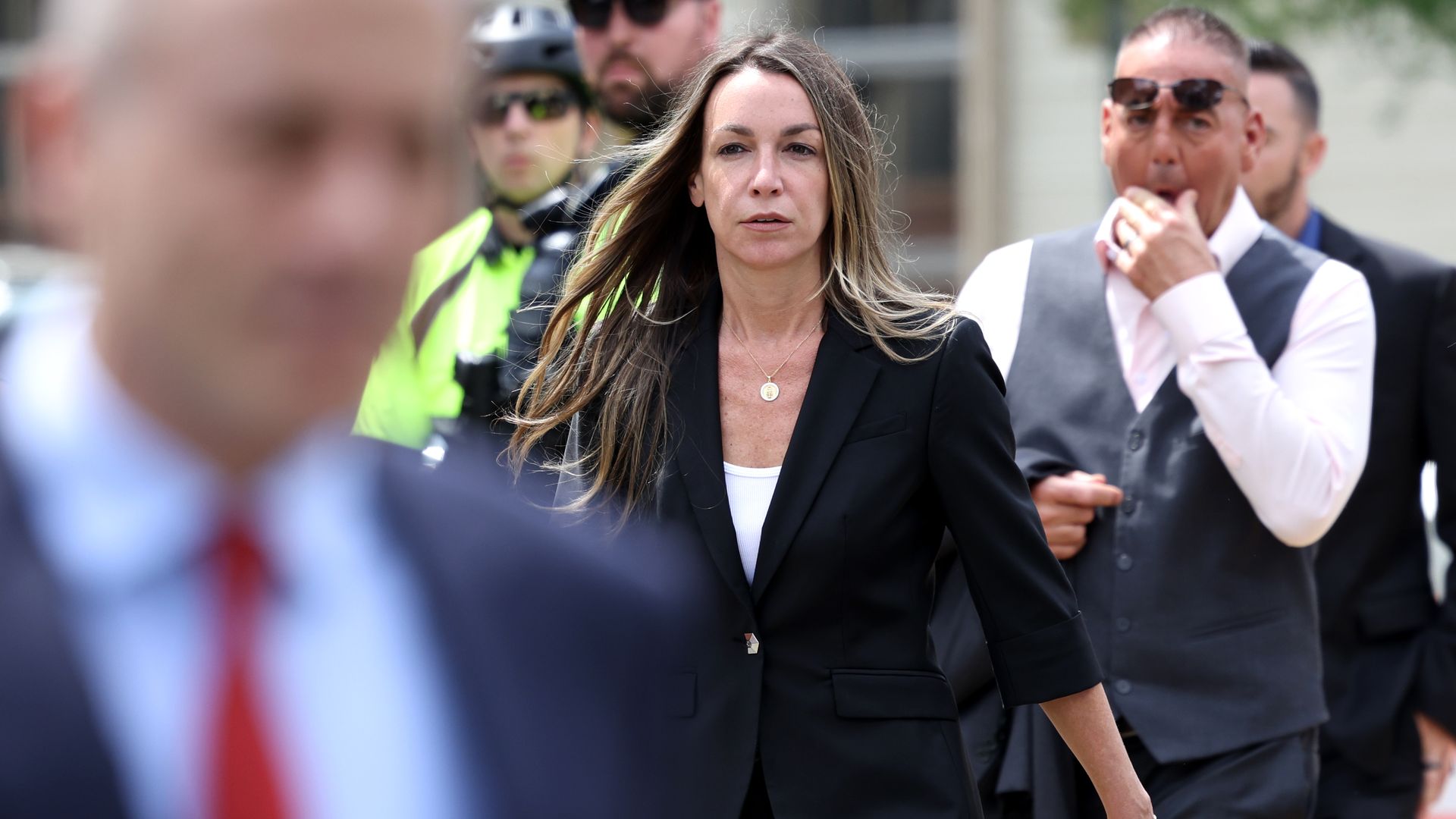 Karen Read walking outside of court, surrounded by people. 