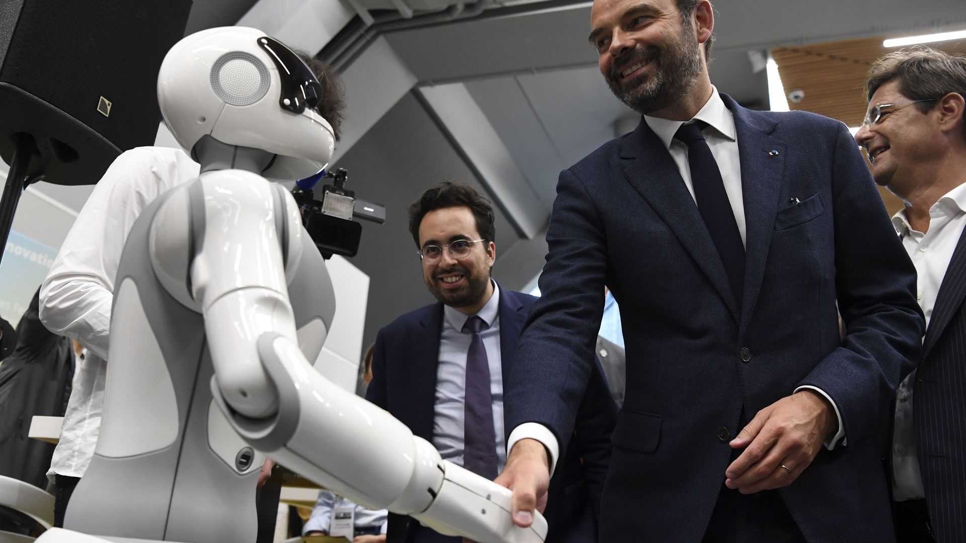 Photo of a man shaking hands with a robot