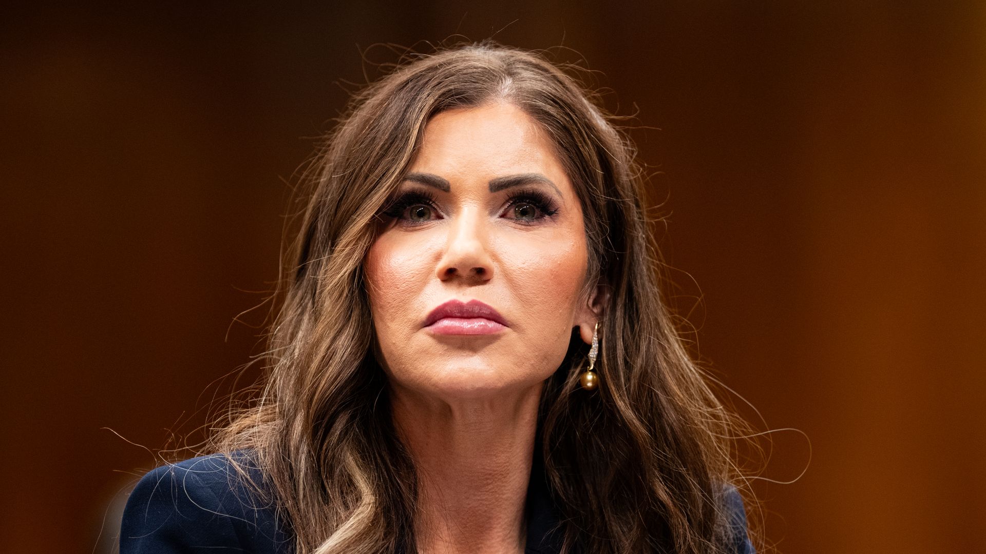 Kristi Noem photographed with a brown background 