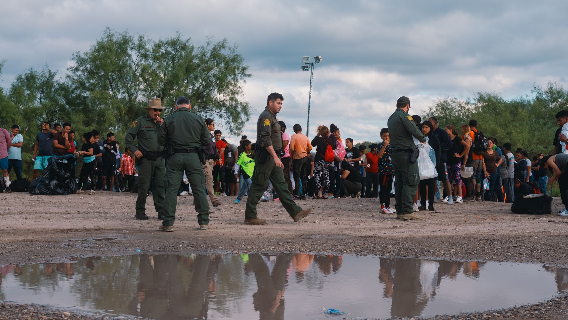 Migrants wait in line to be processed by US Border Patrol agents after crossing the Rio Grande River in Eagle Pass, Texas
