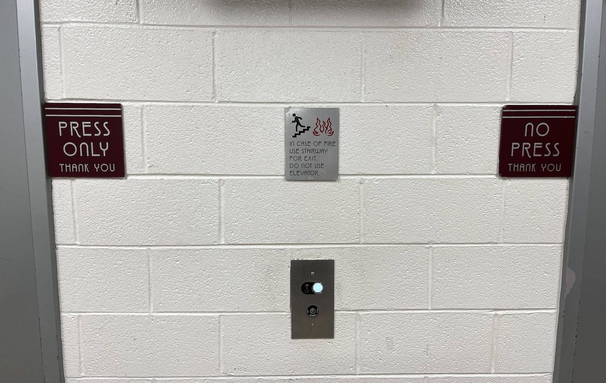 Photo of a wall with two signs saying "press only" and "no press" 