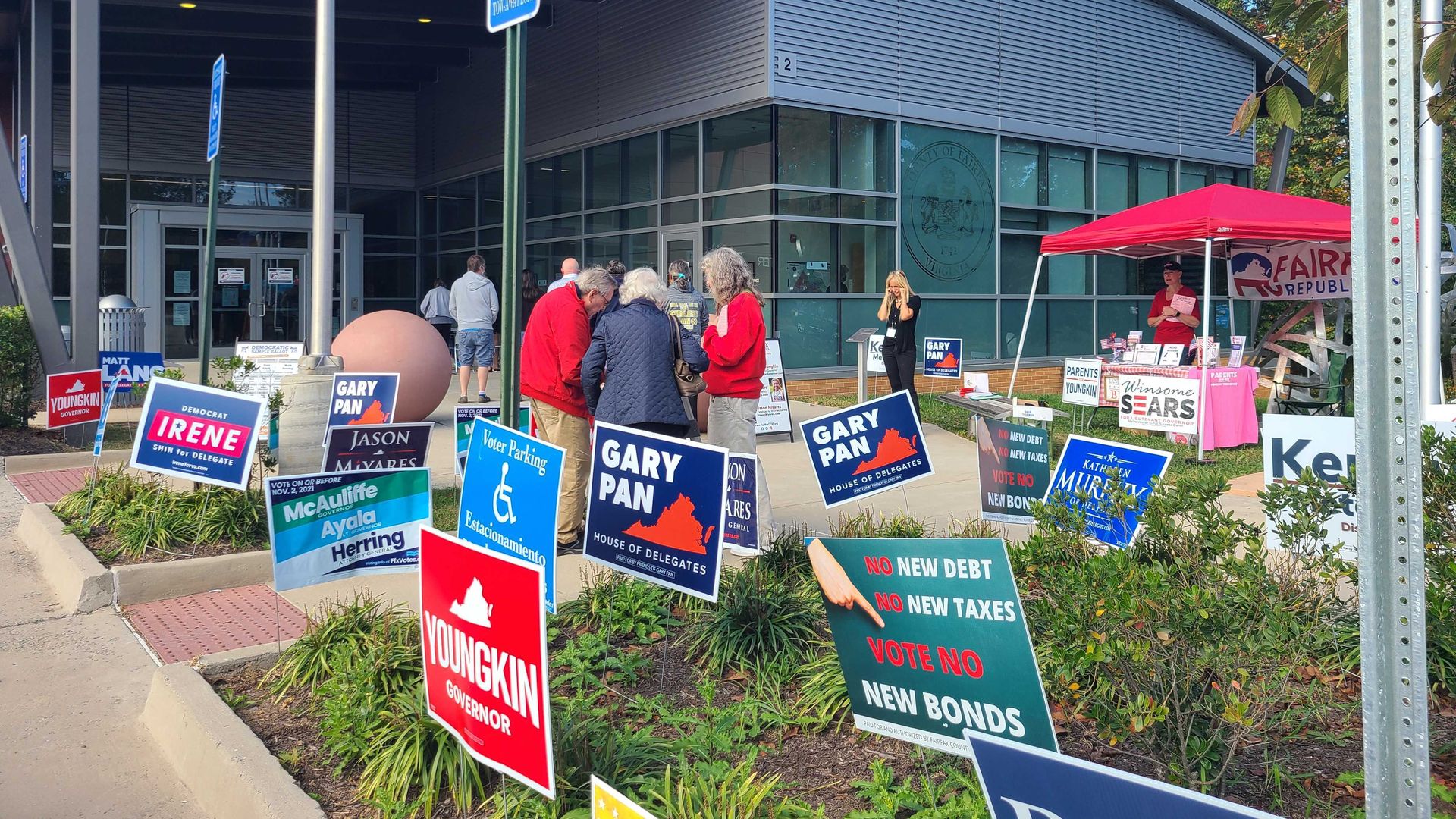 A look outside a Virginia polling place with lots of election signs out front.