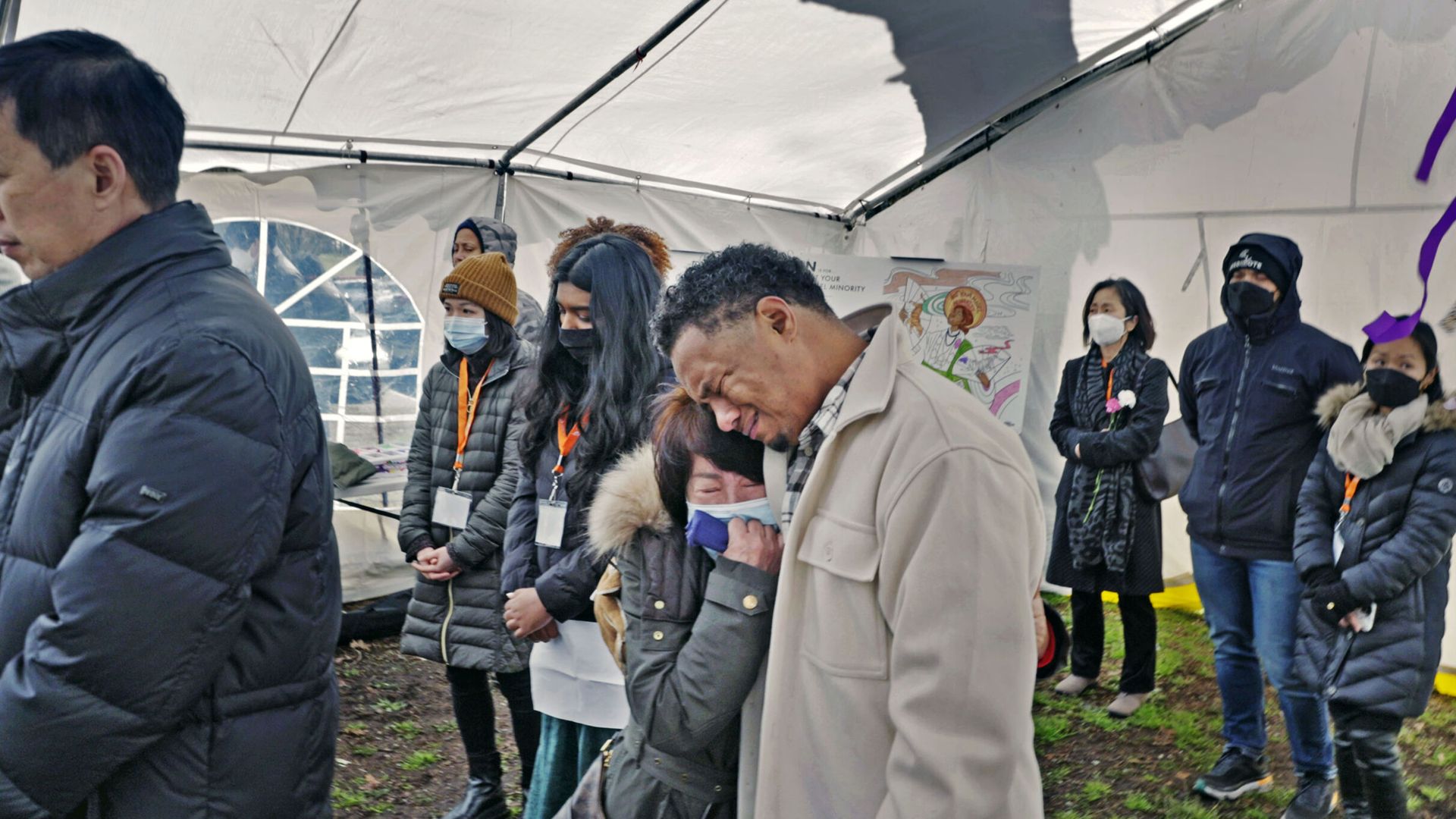 Photo of Robert Peterson crying as he comforts a woman 