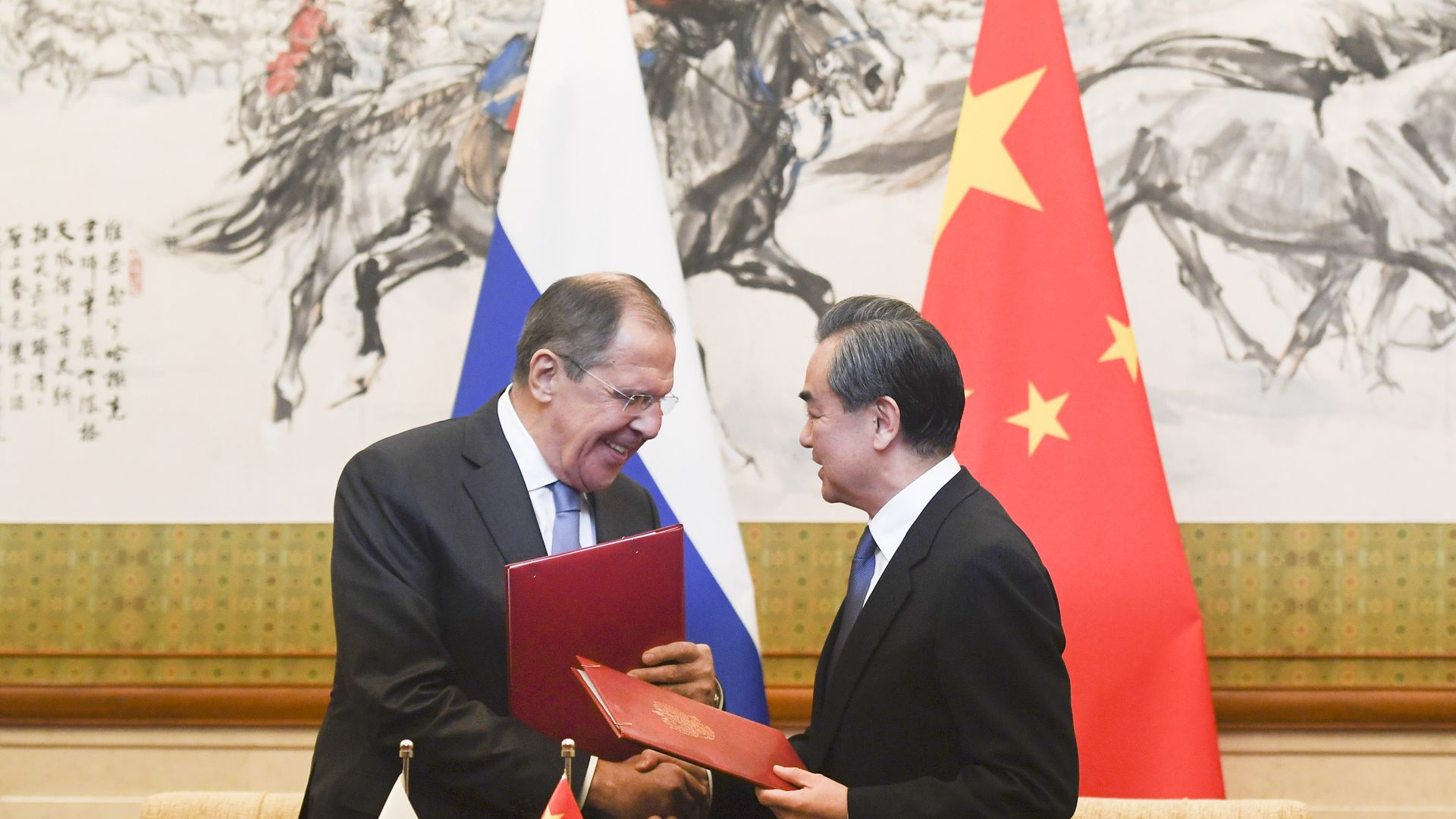 Russia's Foreign Minister Sergei Lavrov shakes hands with Chinese Foreign Minister Wang Yi 