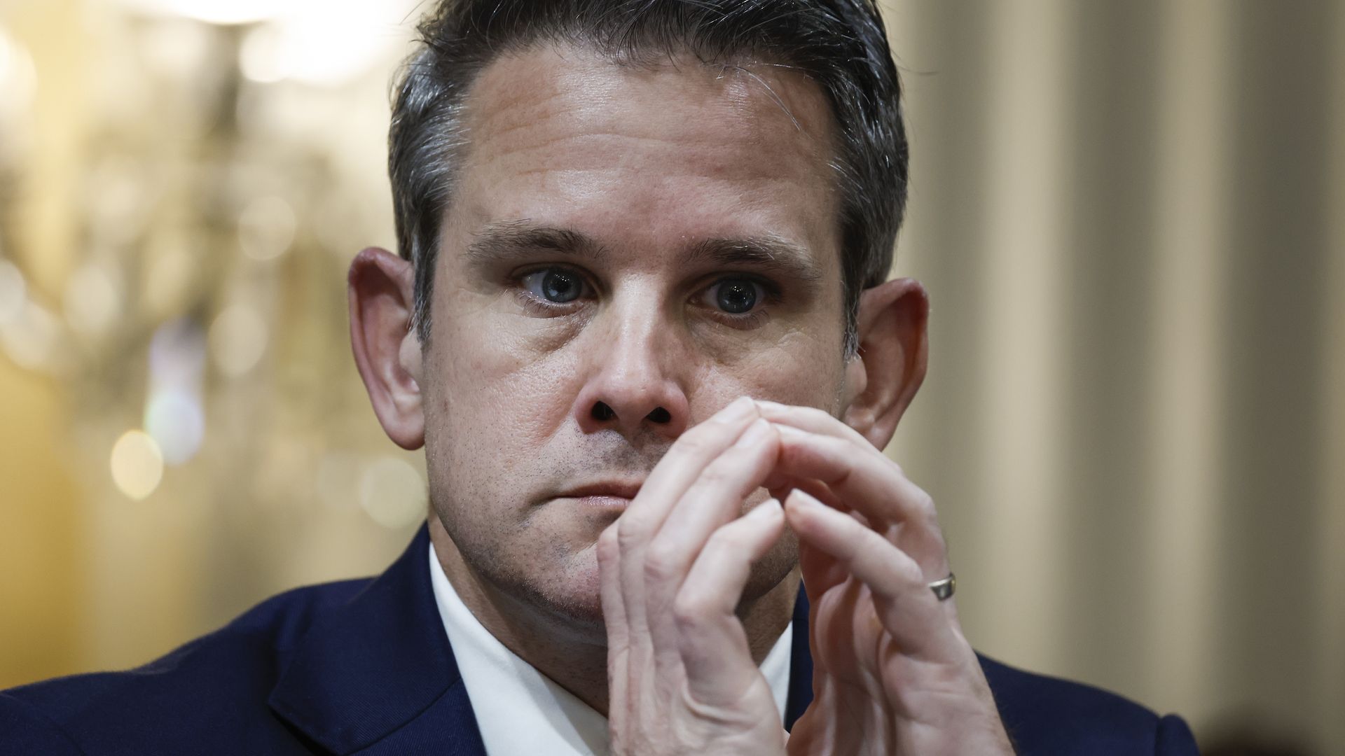 Politician with hands in front of face