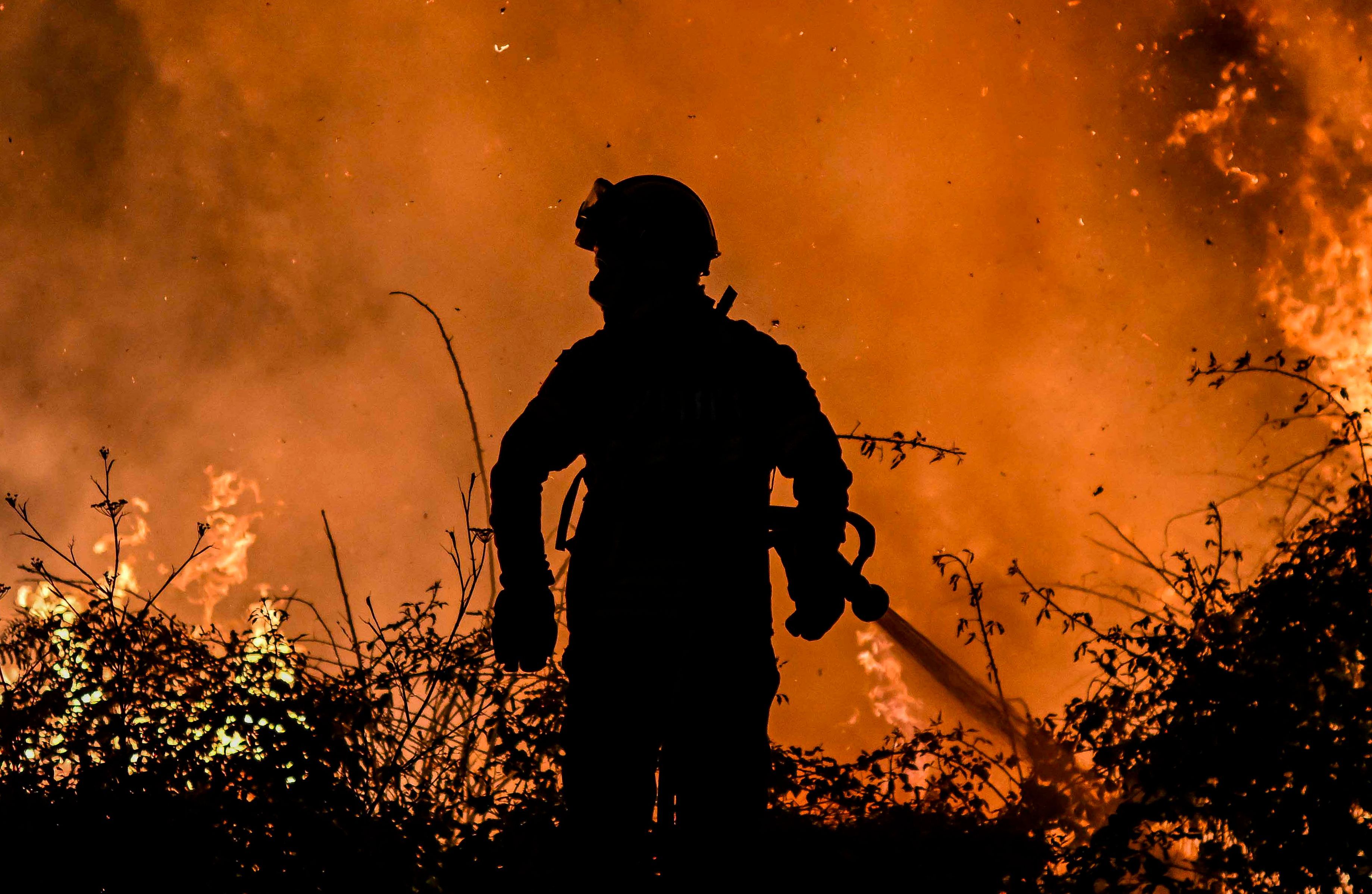 A firefighter tackles a forest fire around the village of Eiriz in Baiao, north of Portugal, on July 15, 2022. (Photo by Patricia De Melo MOREIRA 