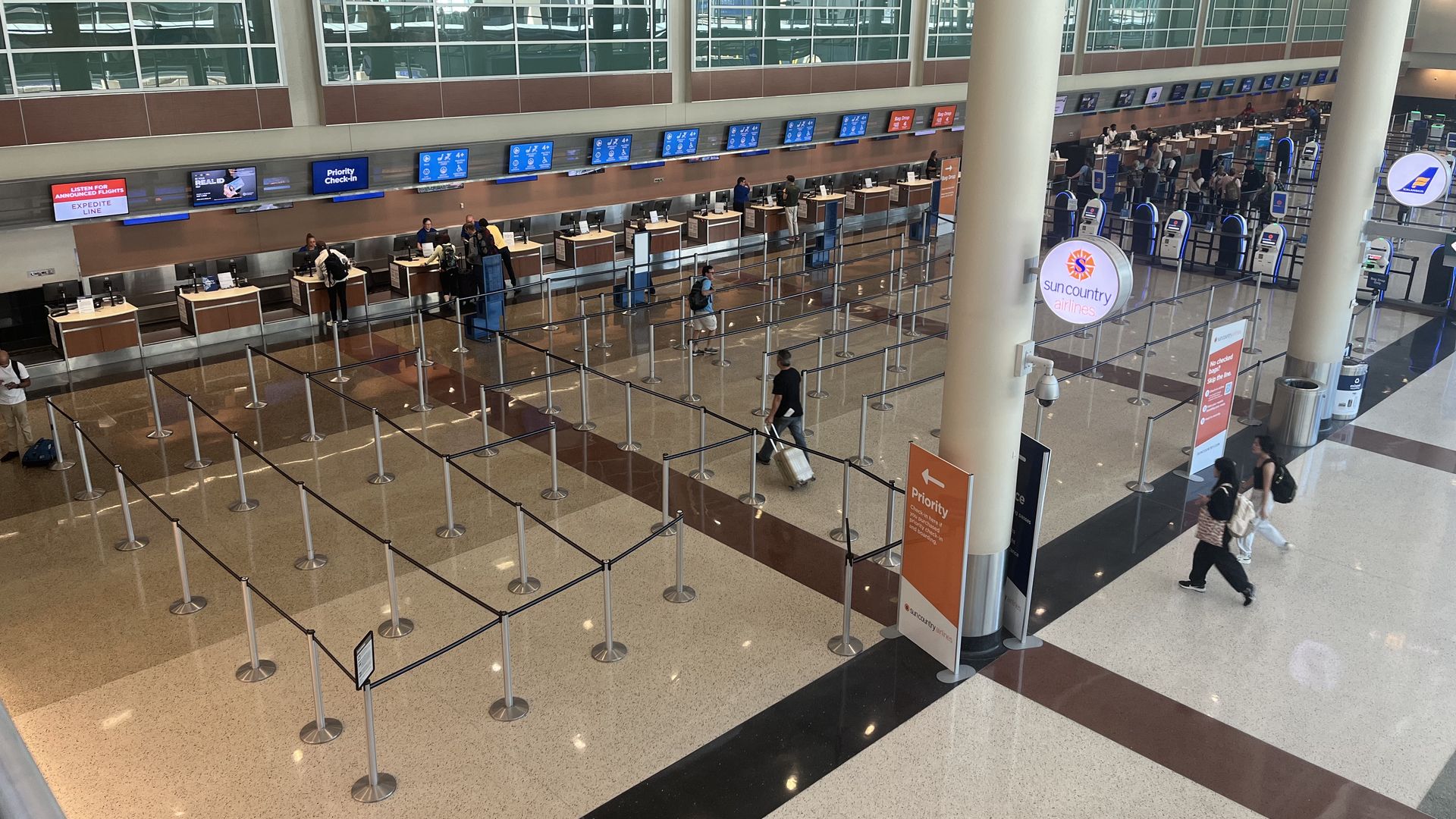 A photo of a nearly empty check in line at Sun Country's desk at the airport 