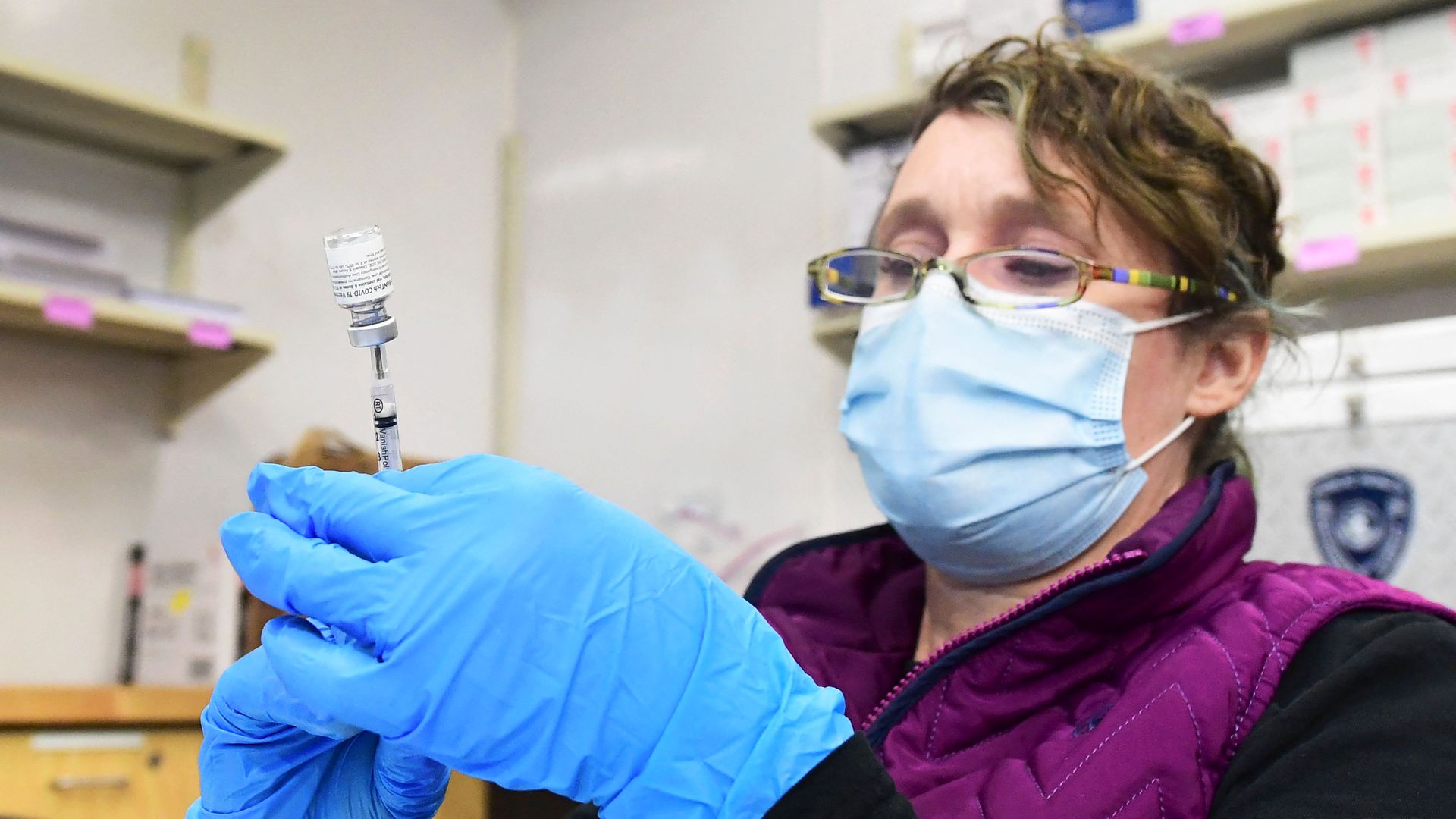Registered Nurse Morgan James loads a syringe with a dose of the Pfizer Covid-19 vaccine