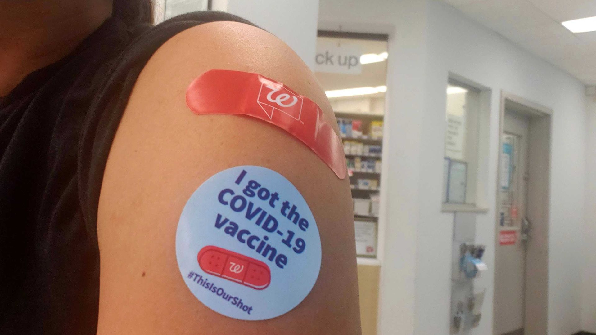 Arm with a sticker and bandaid for vaccine