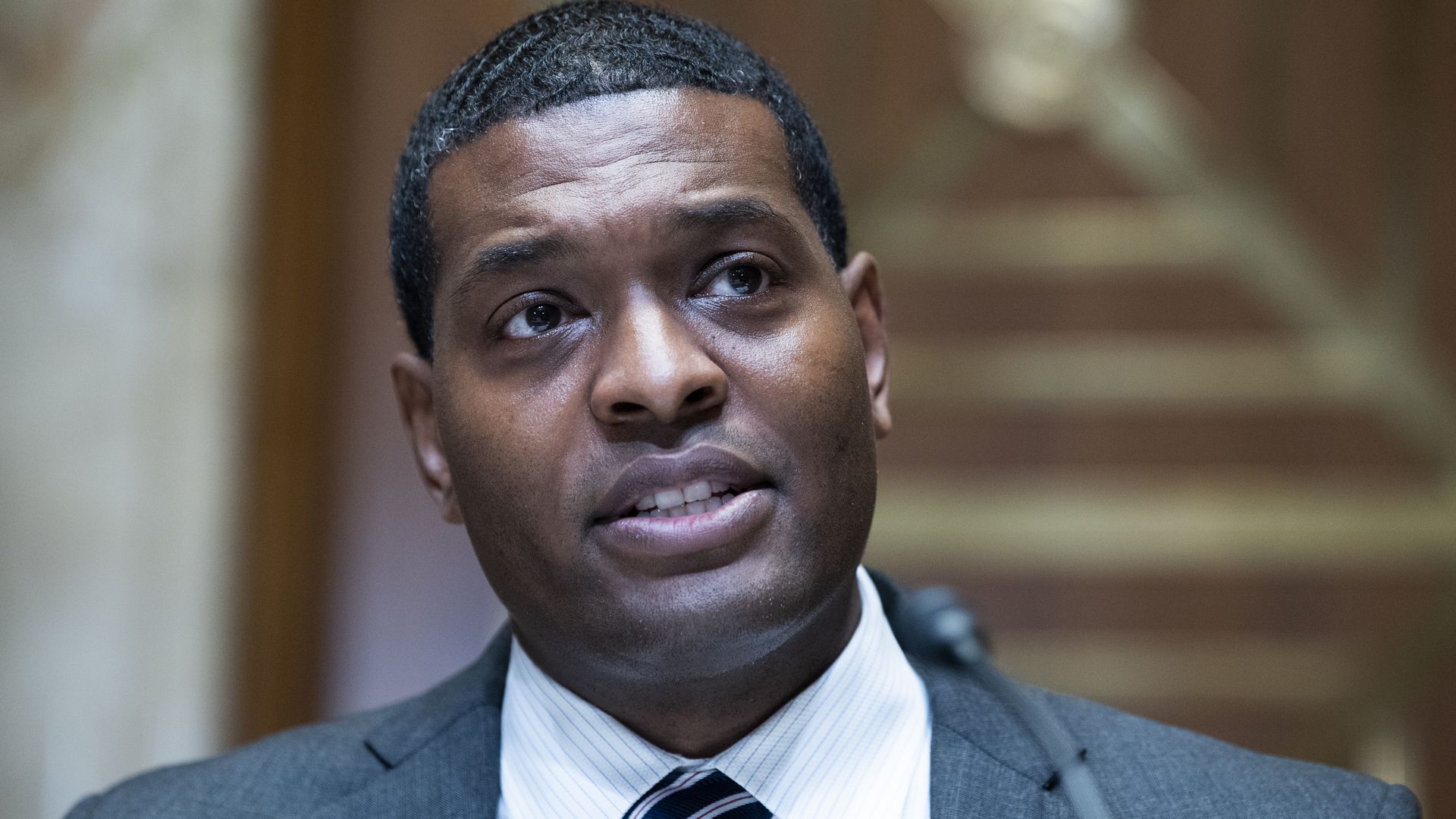 Photo of Michael Regan wearing a suit and speaking