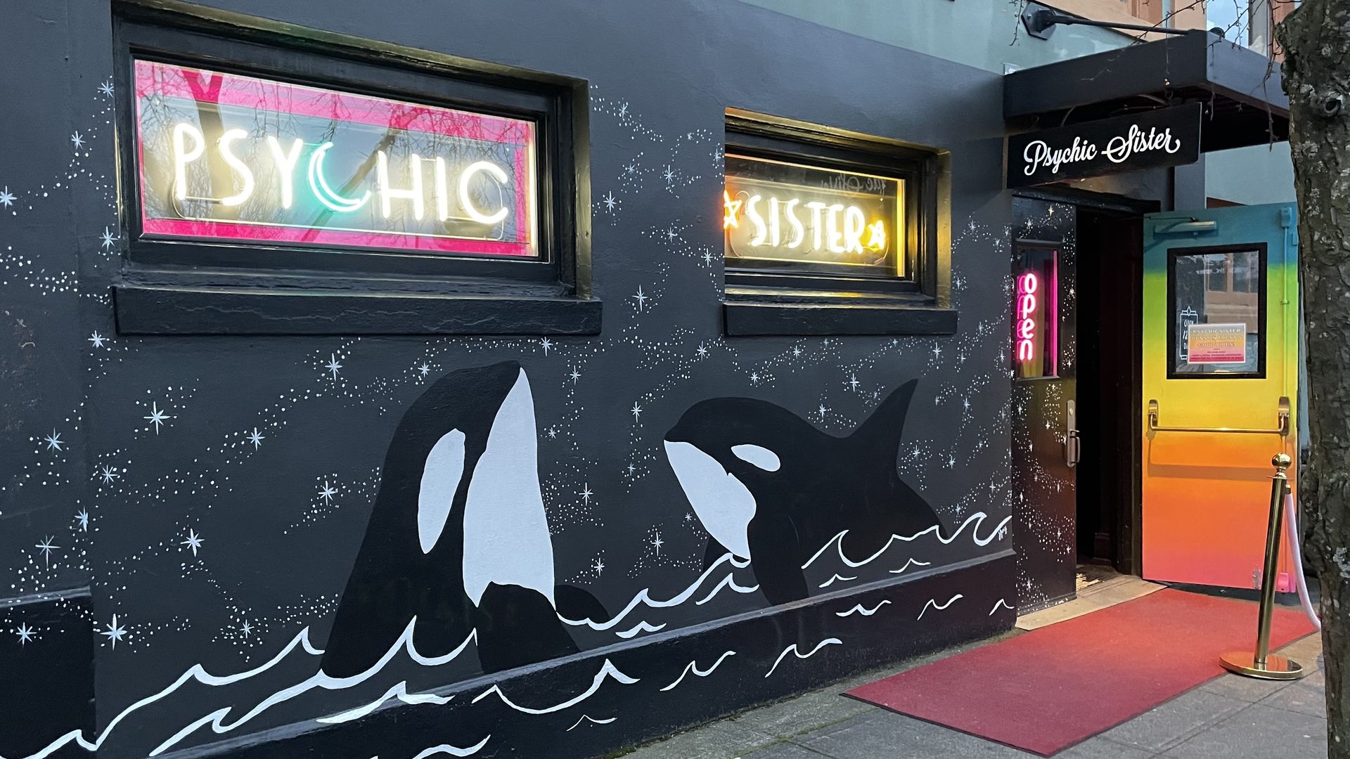 An image of a storefront with a mural of two killer whales.