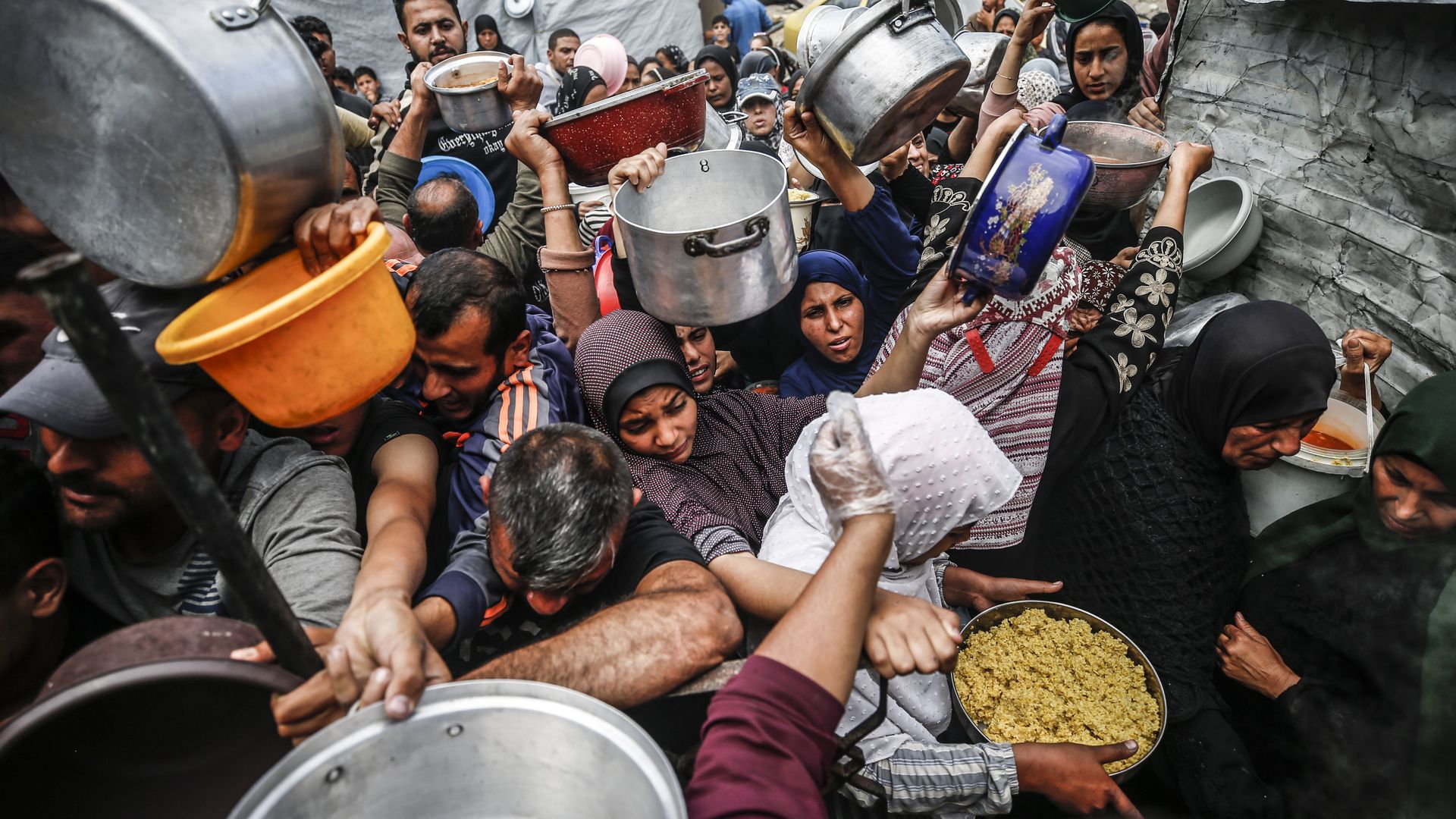 Palestinians, mostly children, wait in long lines with empty pots in hands to get food aid distributed by the charity organizations at the Jabalia Refugee Camp in northern Gaza City, Gaza on April 28, 2025