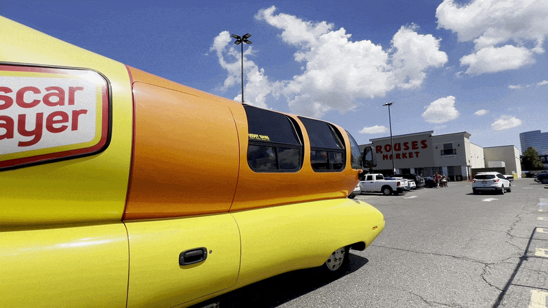 Image shows the Wienermobile driving off.