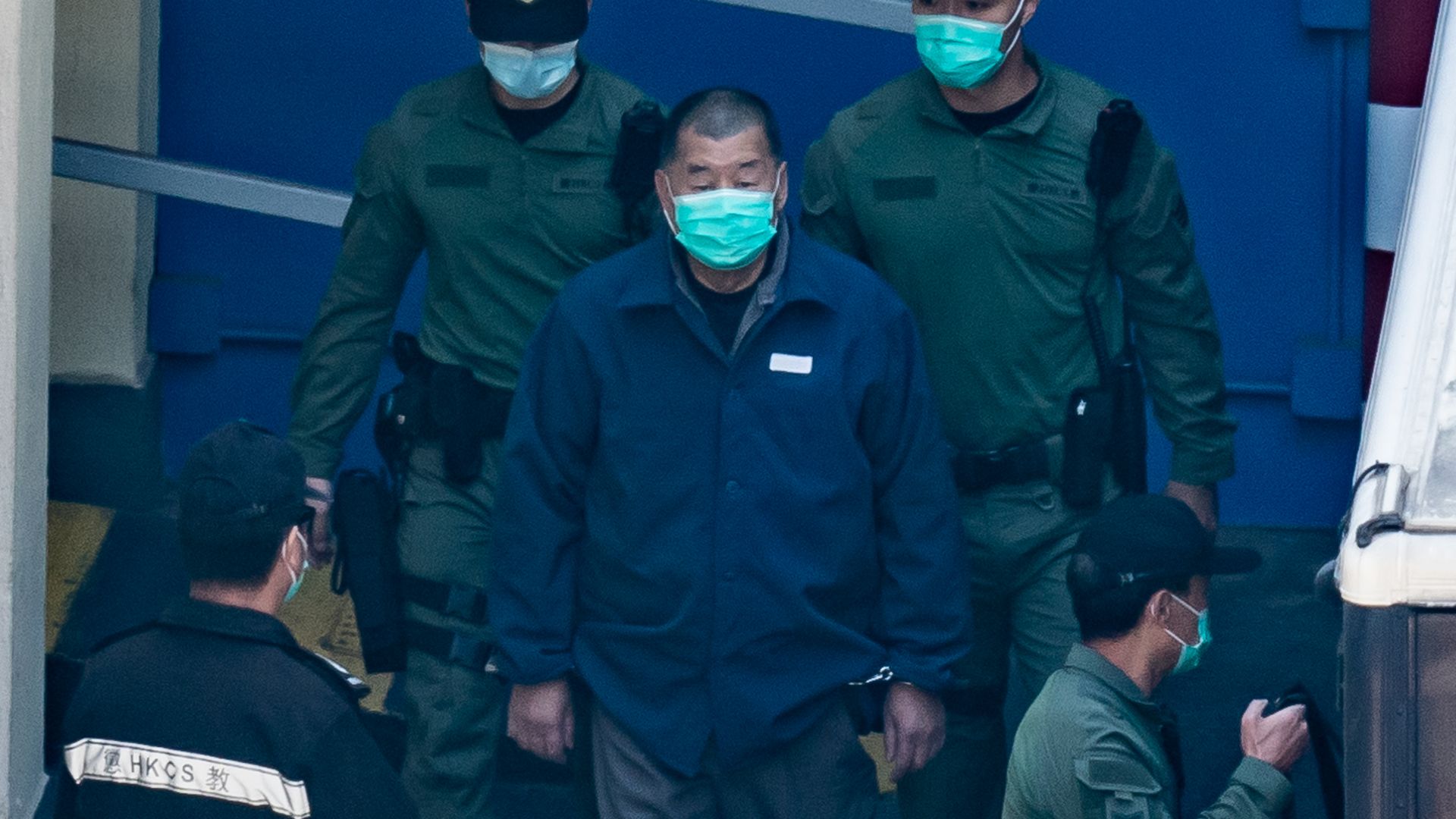 Picture of Jimmy Lai surrounded by security officials