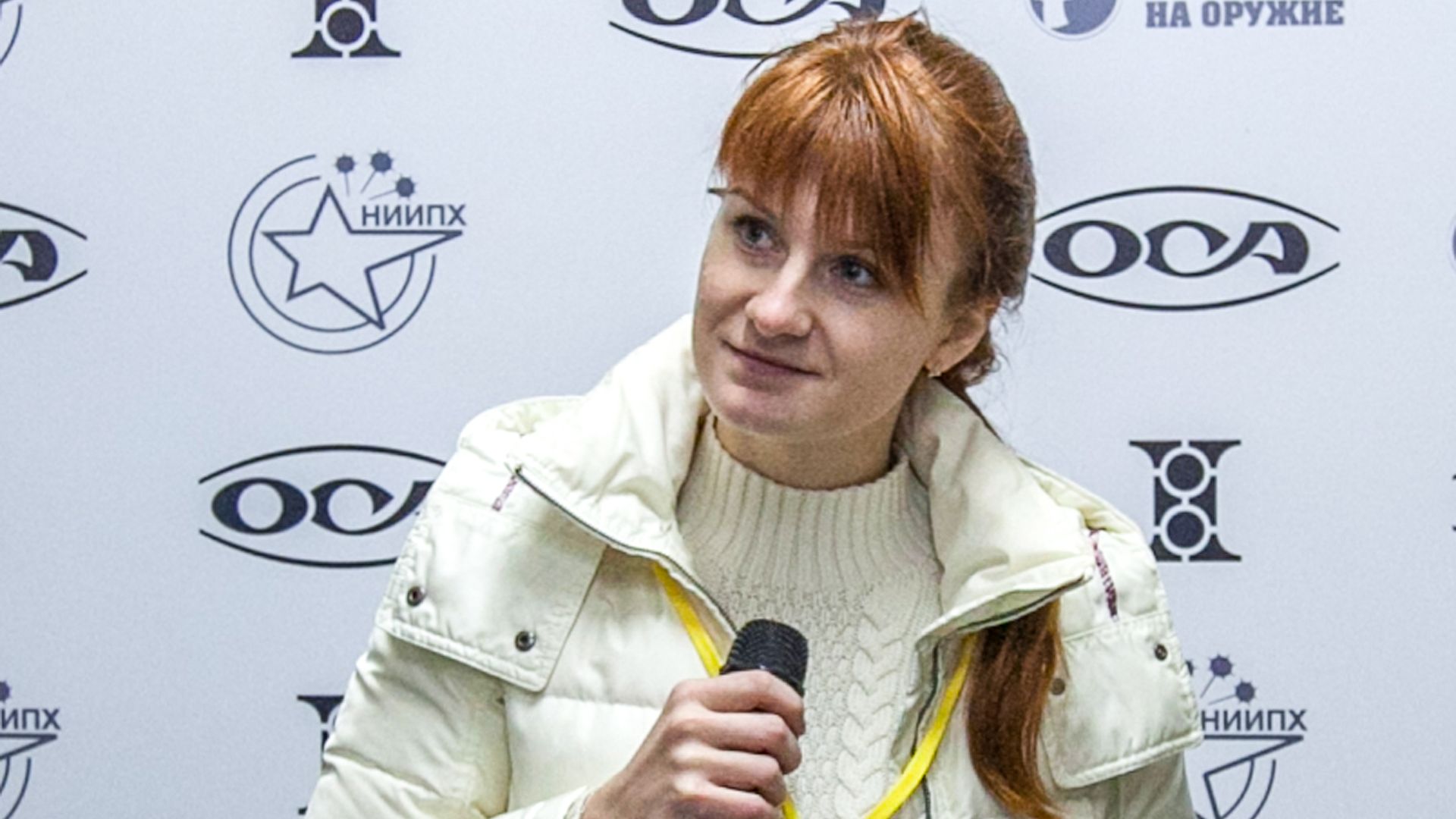 In this image, Maria Butina speaks into a microphone. 
