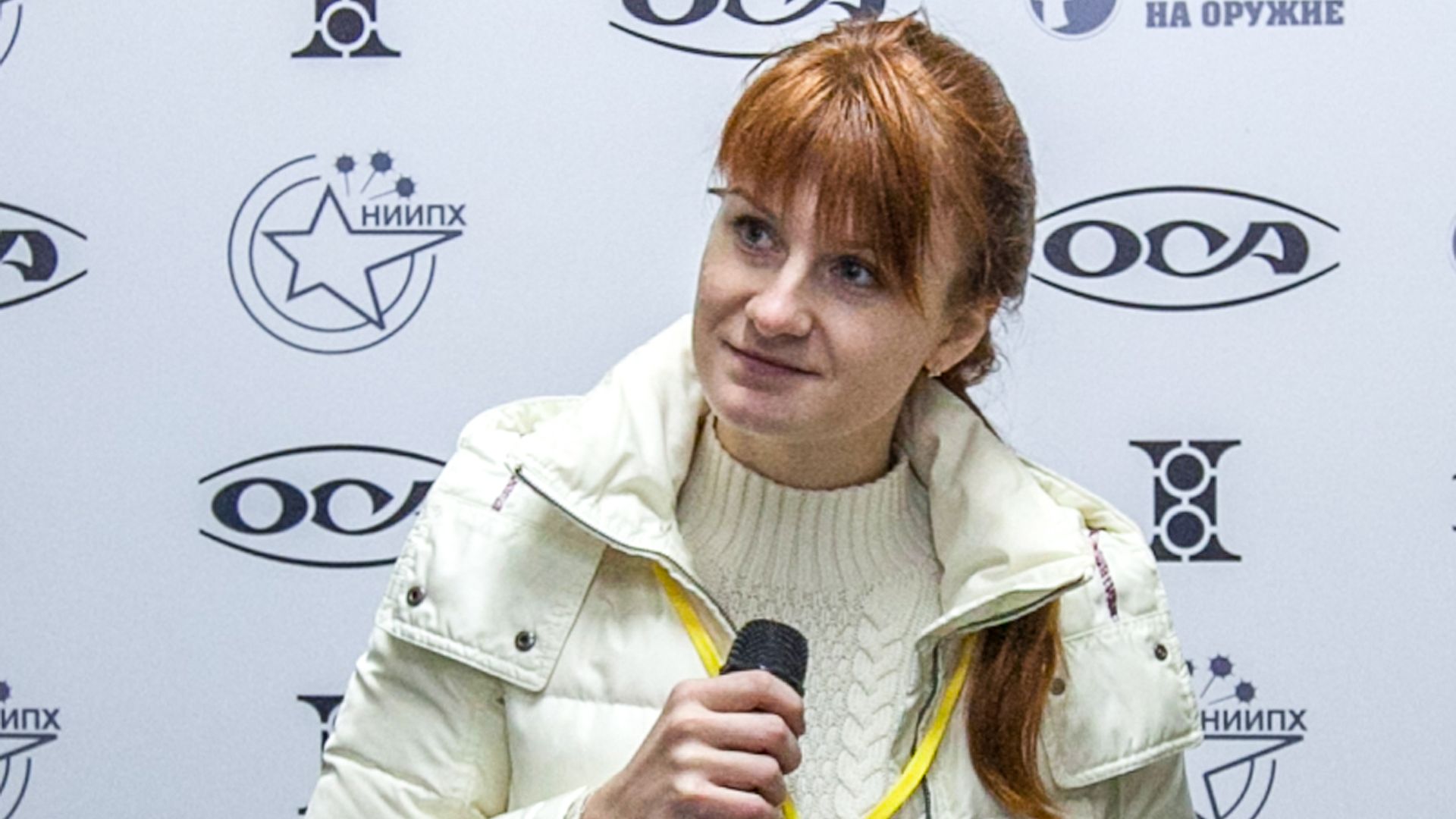 In this image, Maria Butina speaks into a microphone.