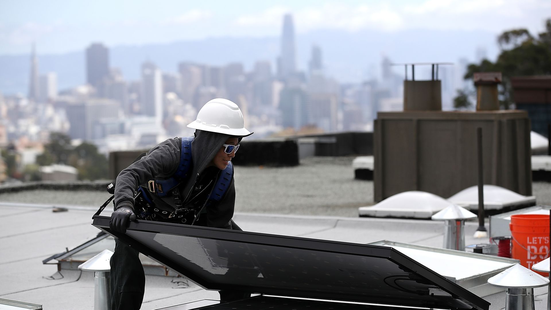 Luminalt solar installers Pam Quan moves a solar panel during an istallation on the roof of a home on May 9, 2018 in San Francisco, California.  