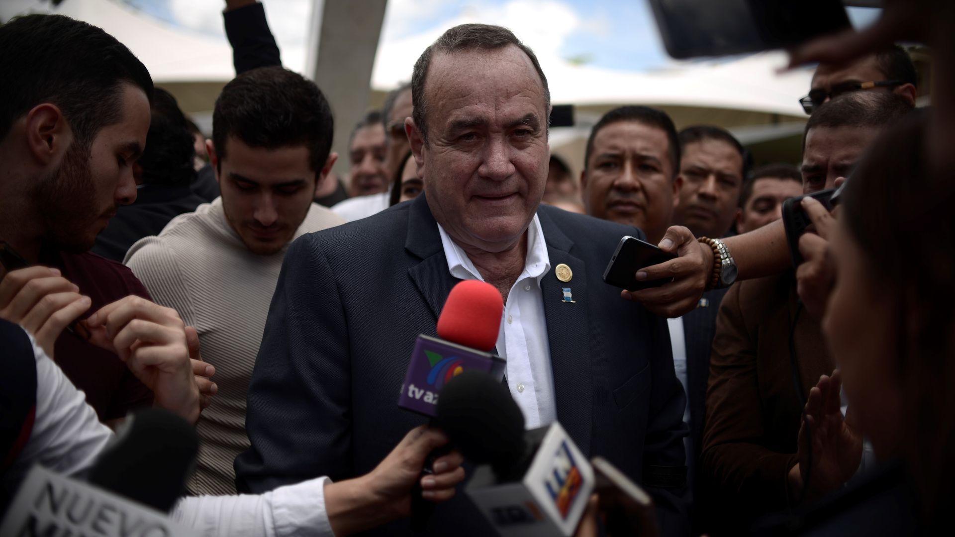 Alejandro Giammettei surrounded by journalists