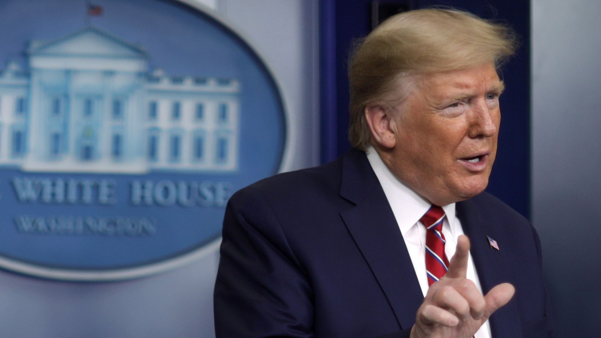 In this image, Trump stands in the White House briefing room