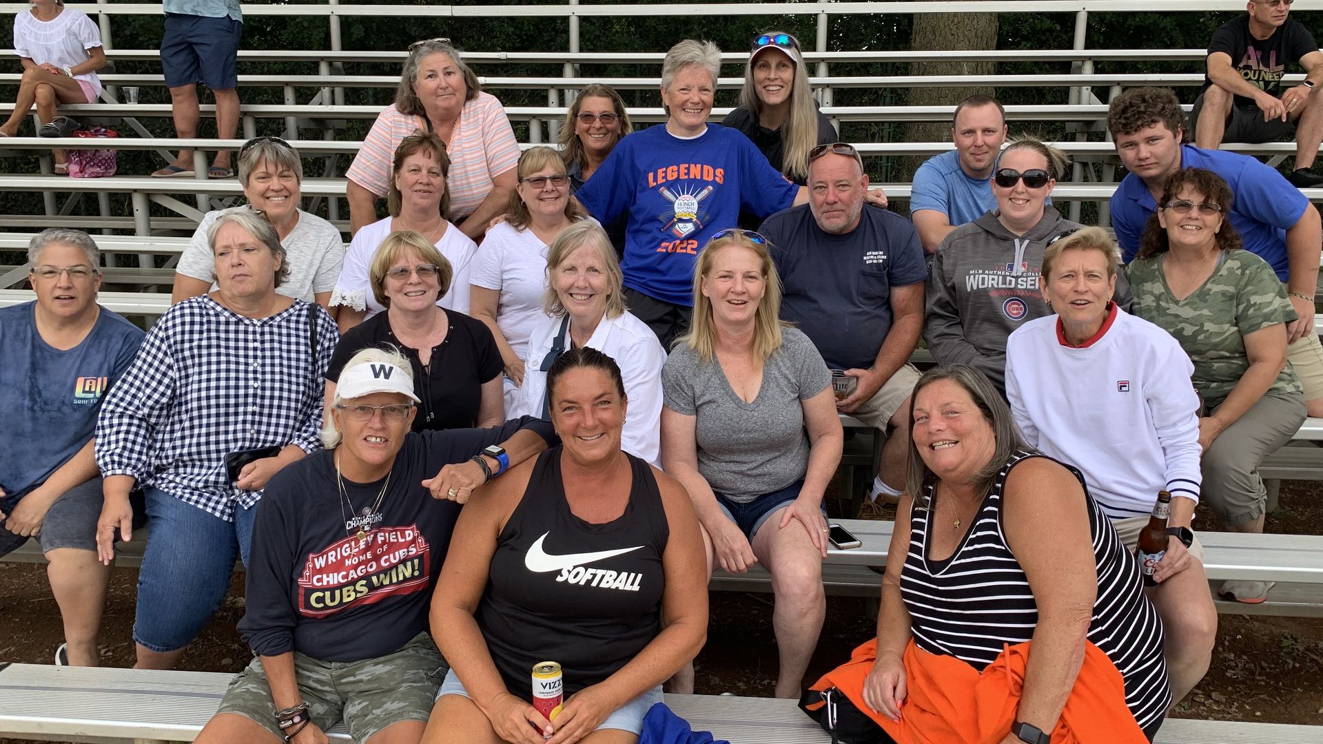 Photo of a group of people posing for photos on bleachers.