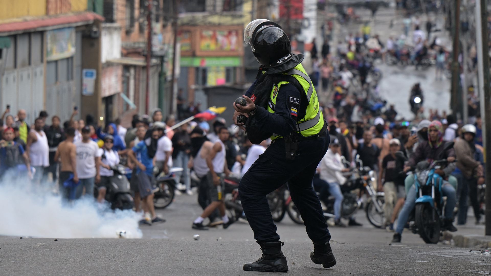A riot police officer uses tear gas against demonstrators during a protest by opponents of Venezuelan President Nicolas Maduro's government in the Catia neighborhood of Caracas on July 29, 2024, a day after the Venezuelan presidential election. 