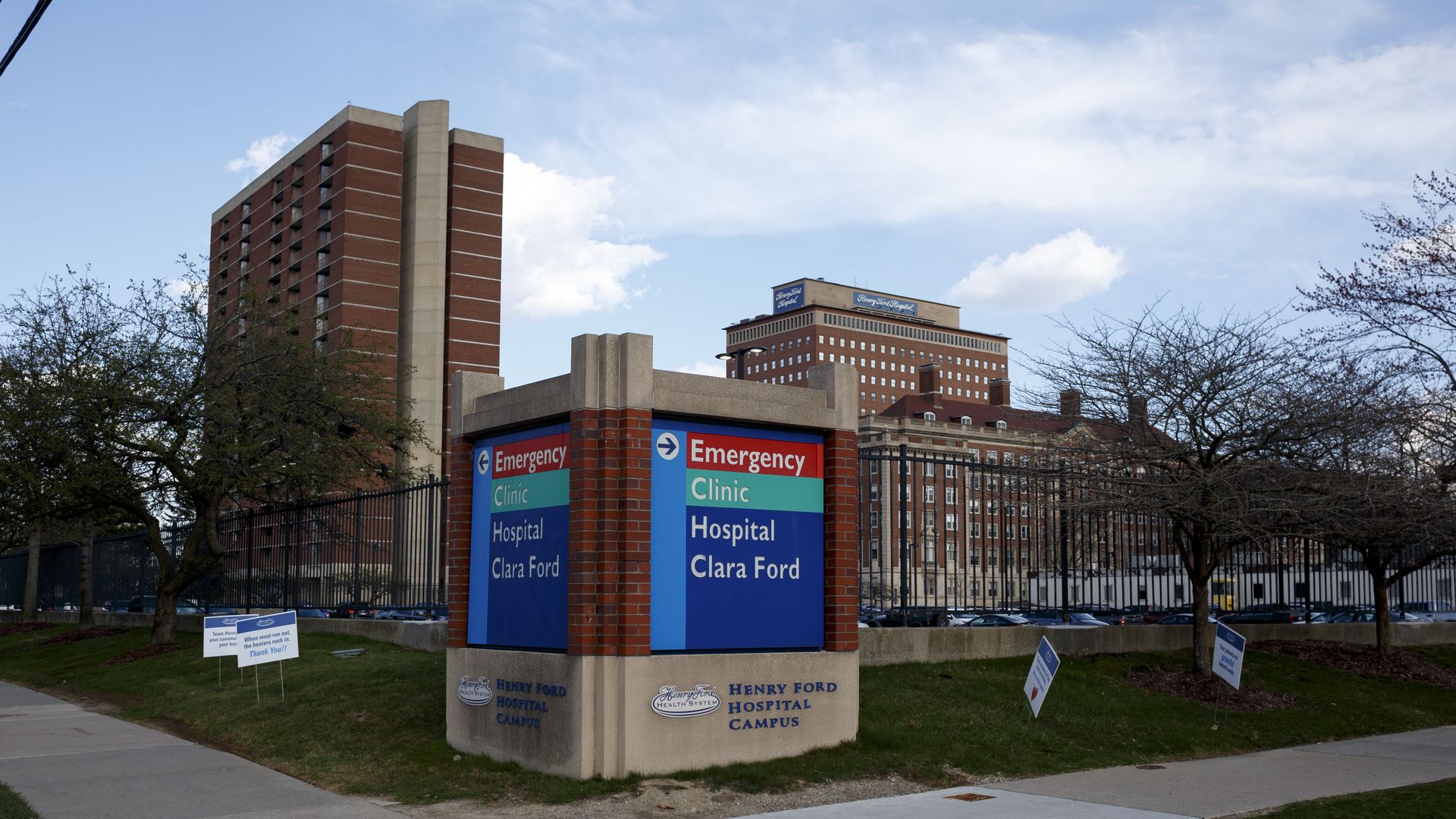 A hospital sign with the Henry Ford Hospital name on it and the hospital building in the background.