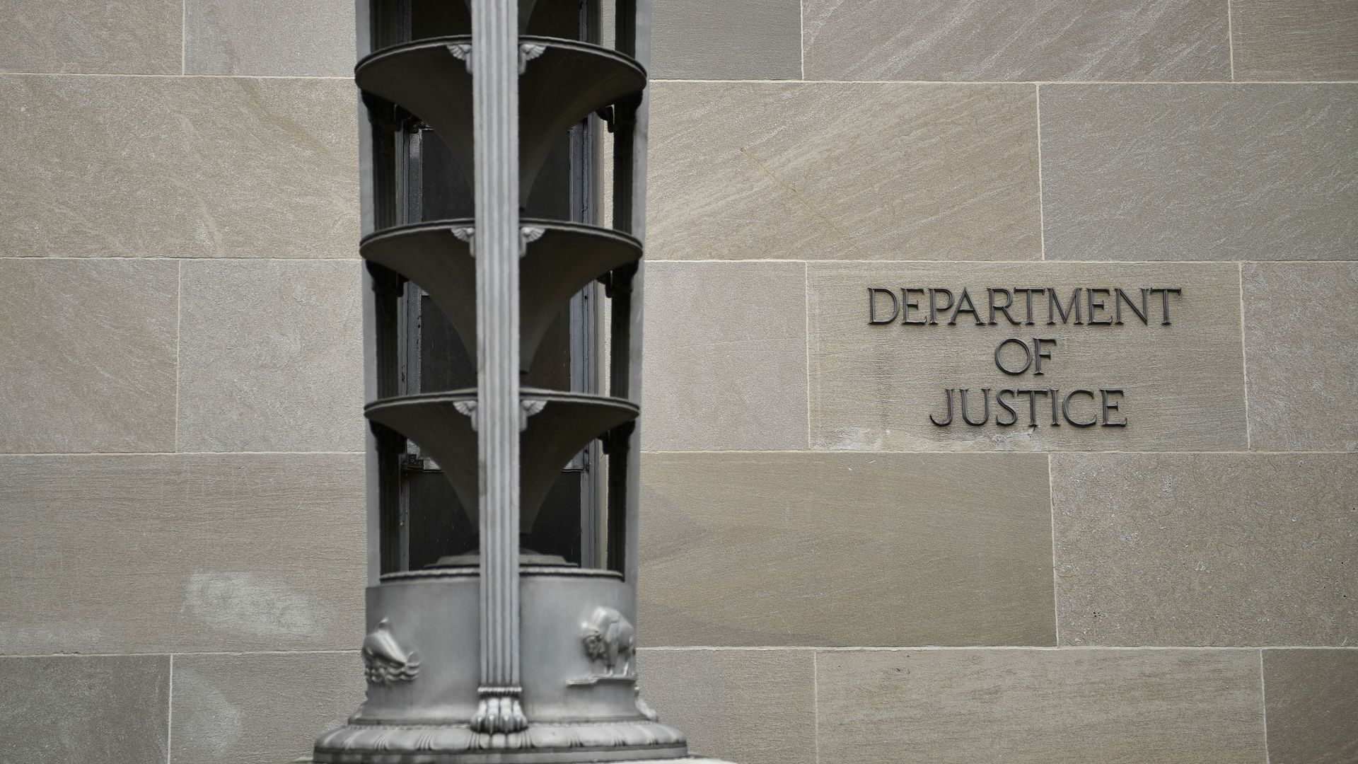 Photo of the outside of the DOJ building with a sign that says "Department of Justice"