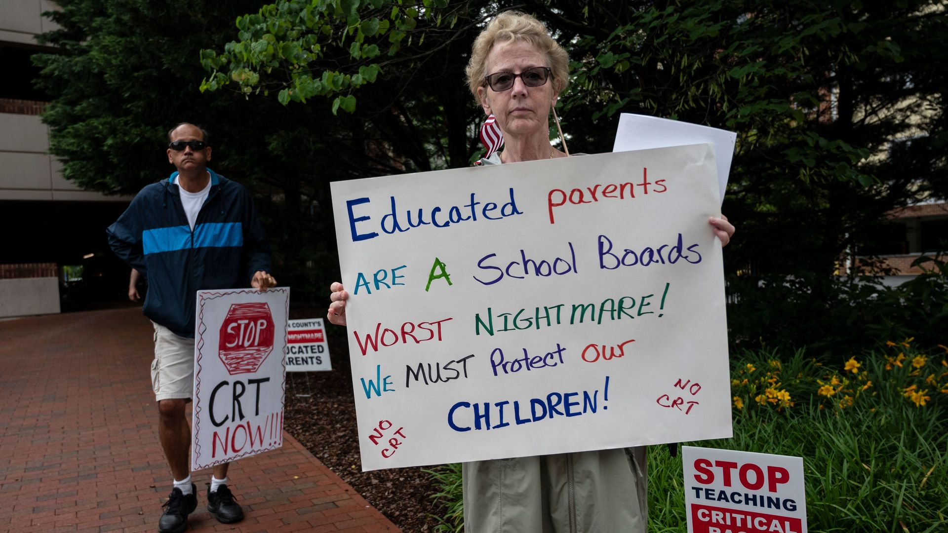 People hold up signs during a rally against "critical race theory" (CRT) being taught in schools at the Loudoun County Government center in Leesburg, Virginia.