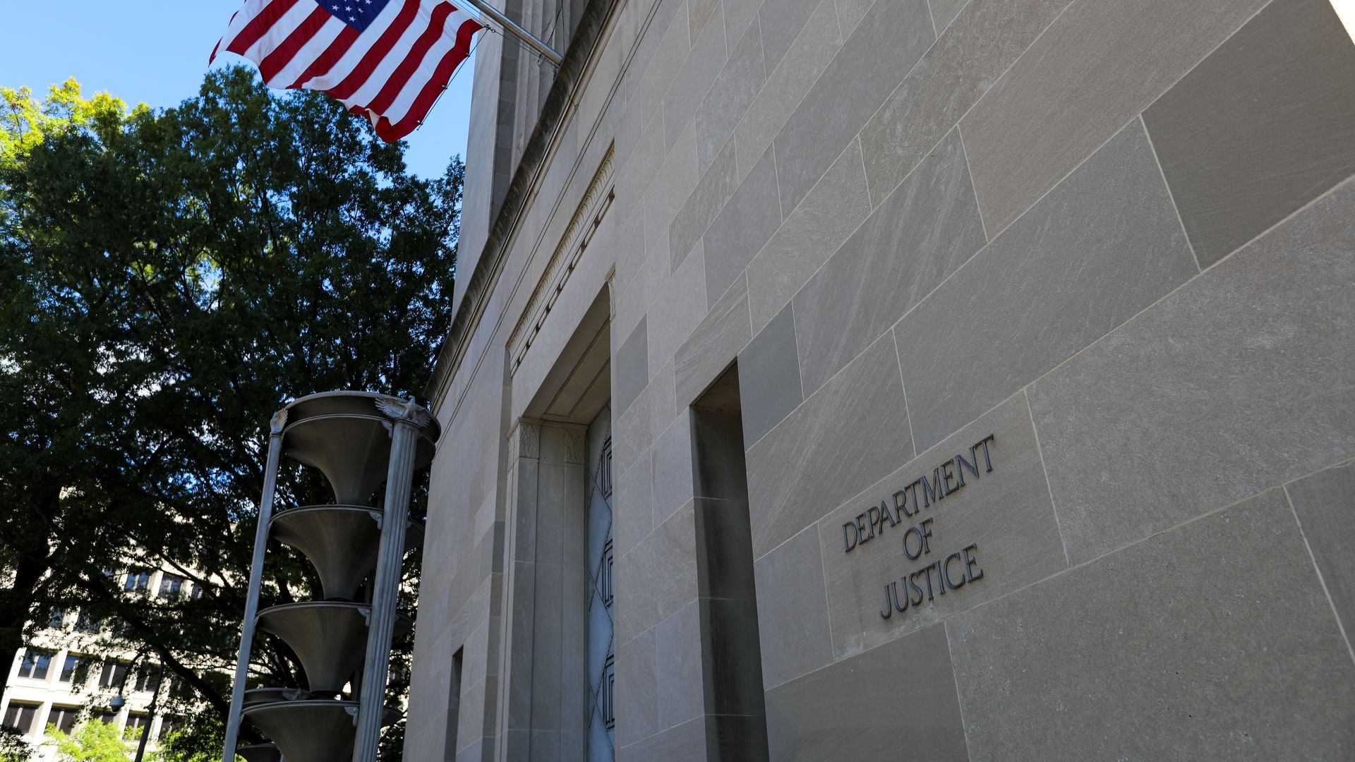 Photo of the front of the Justice Department building, with an American flag hanging off the side