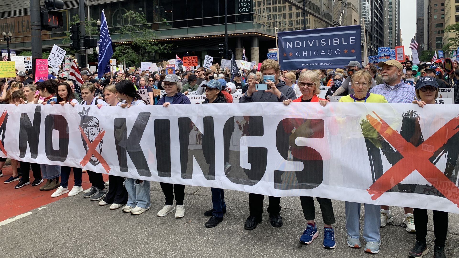 Photo of protesters in streets with banner that says "No Kings" 