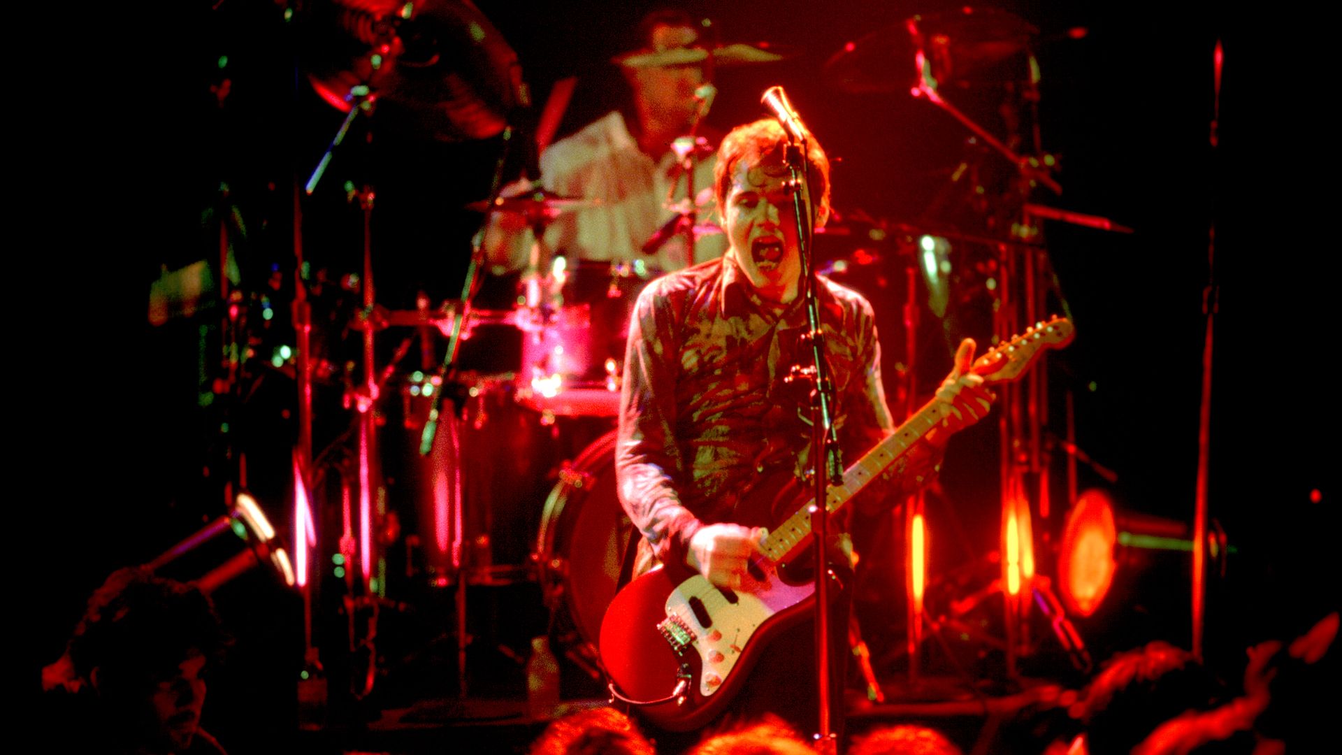 Photo of a rock band on stage. 