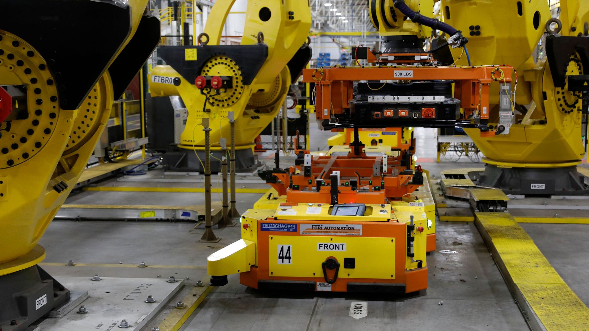 A robot lifts the battery as it is istalled on the frame of Ford Motor Co. battery powered F-150 Lightning trucks.