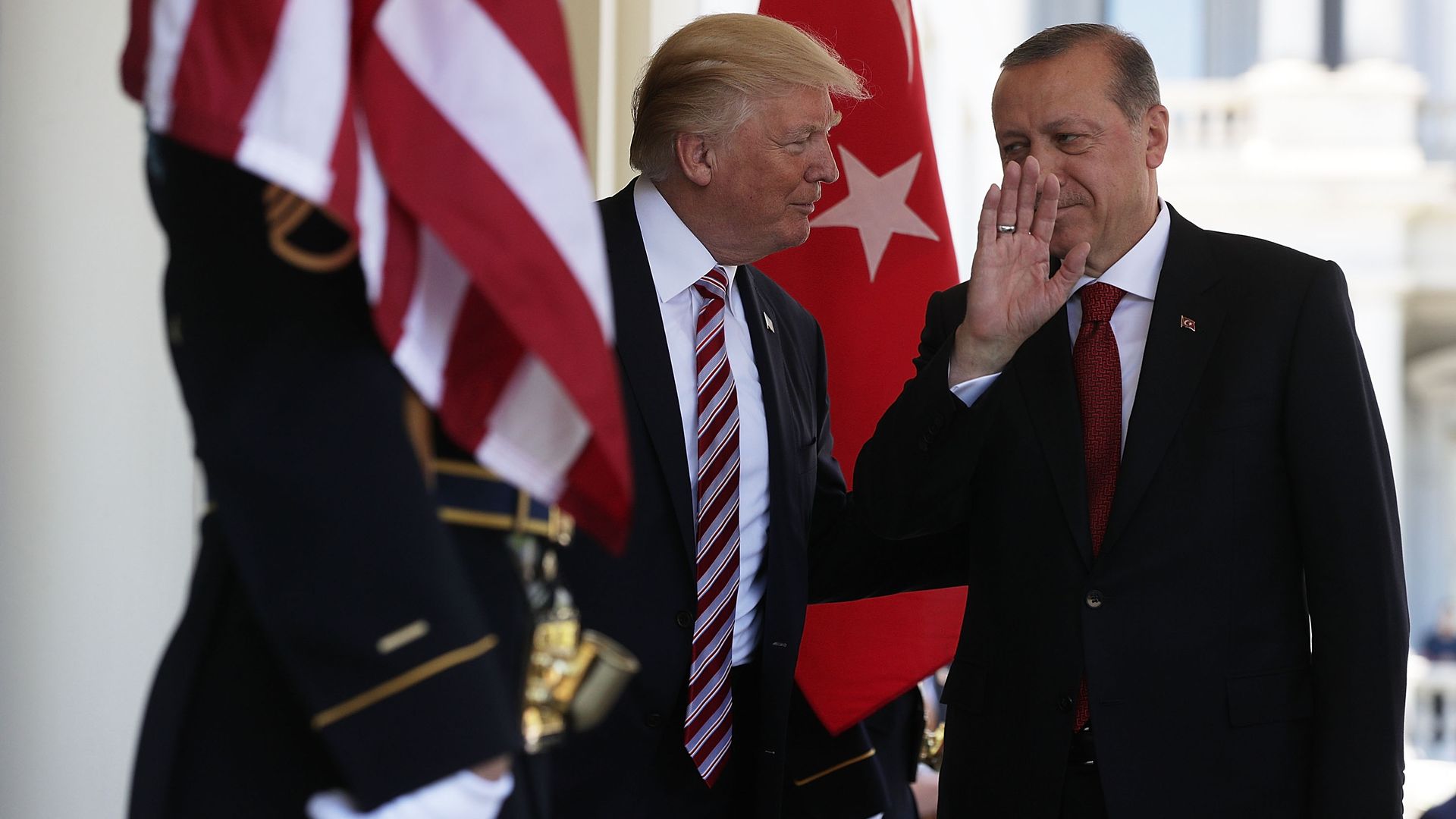 In this image, Trump and the Turkish president speak to each other behind flags