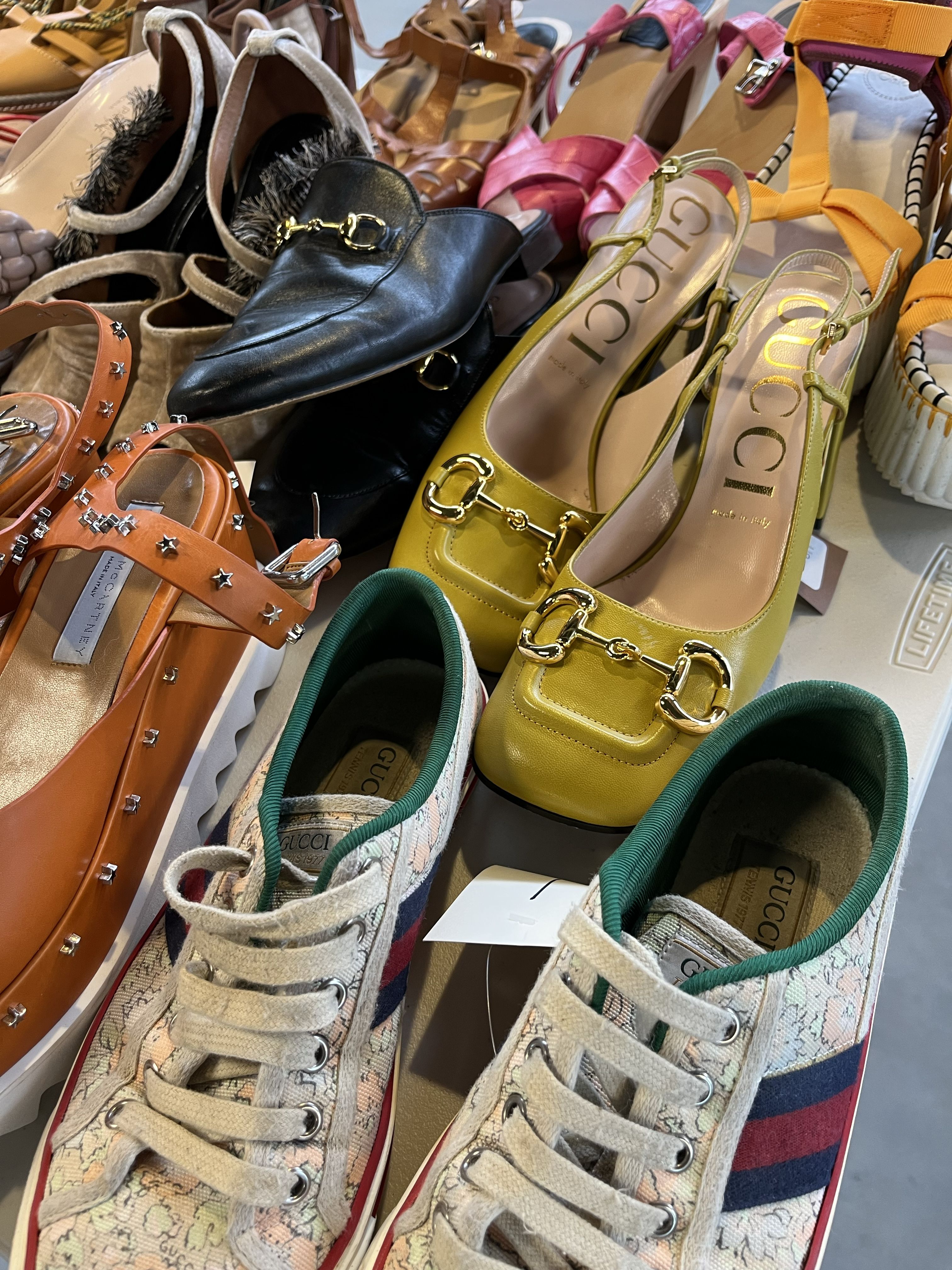 three pairs of gucci shoes in a pile