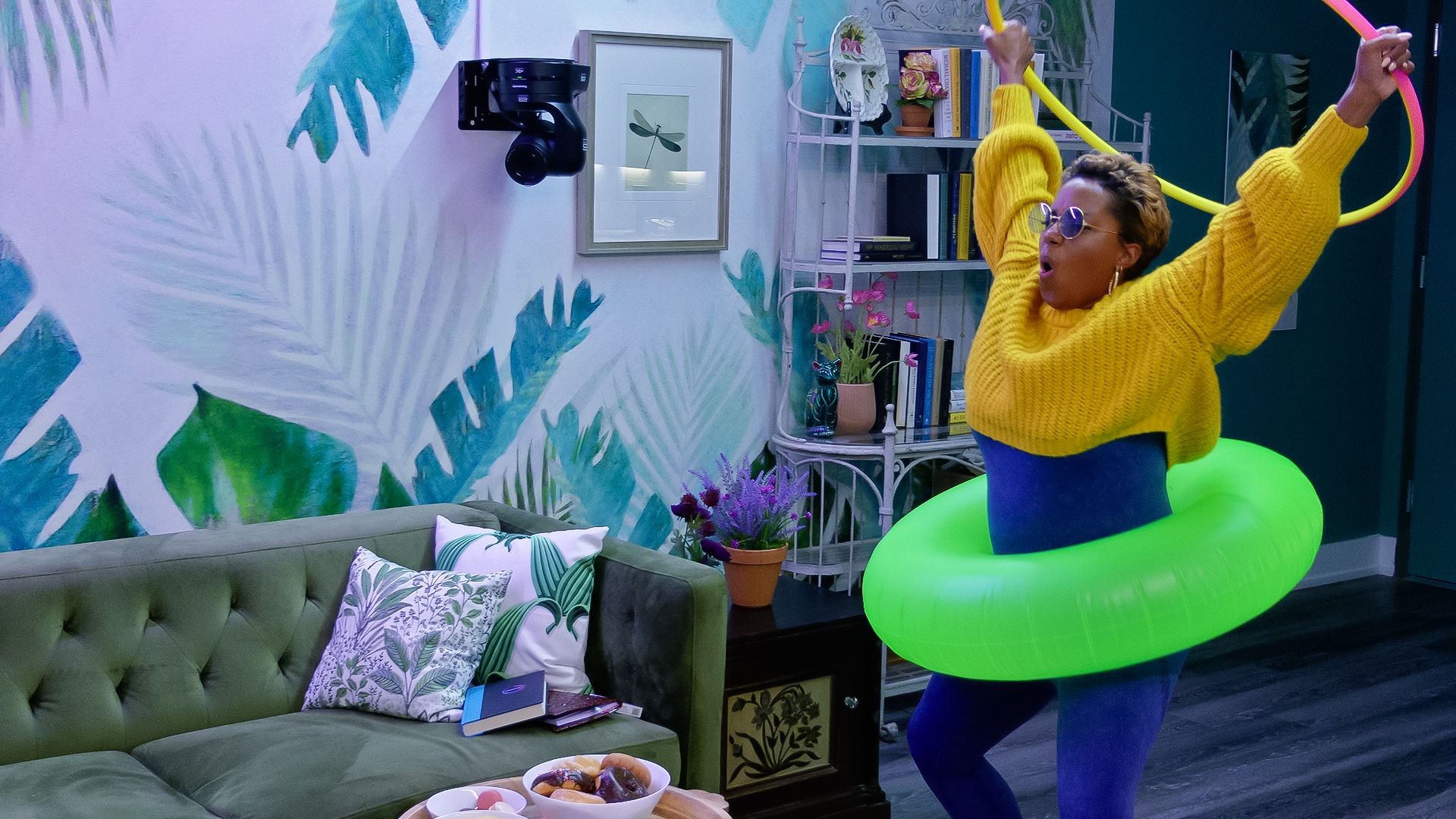 A woman holding a hula hoop and wearing a floatie in an apartment