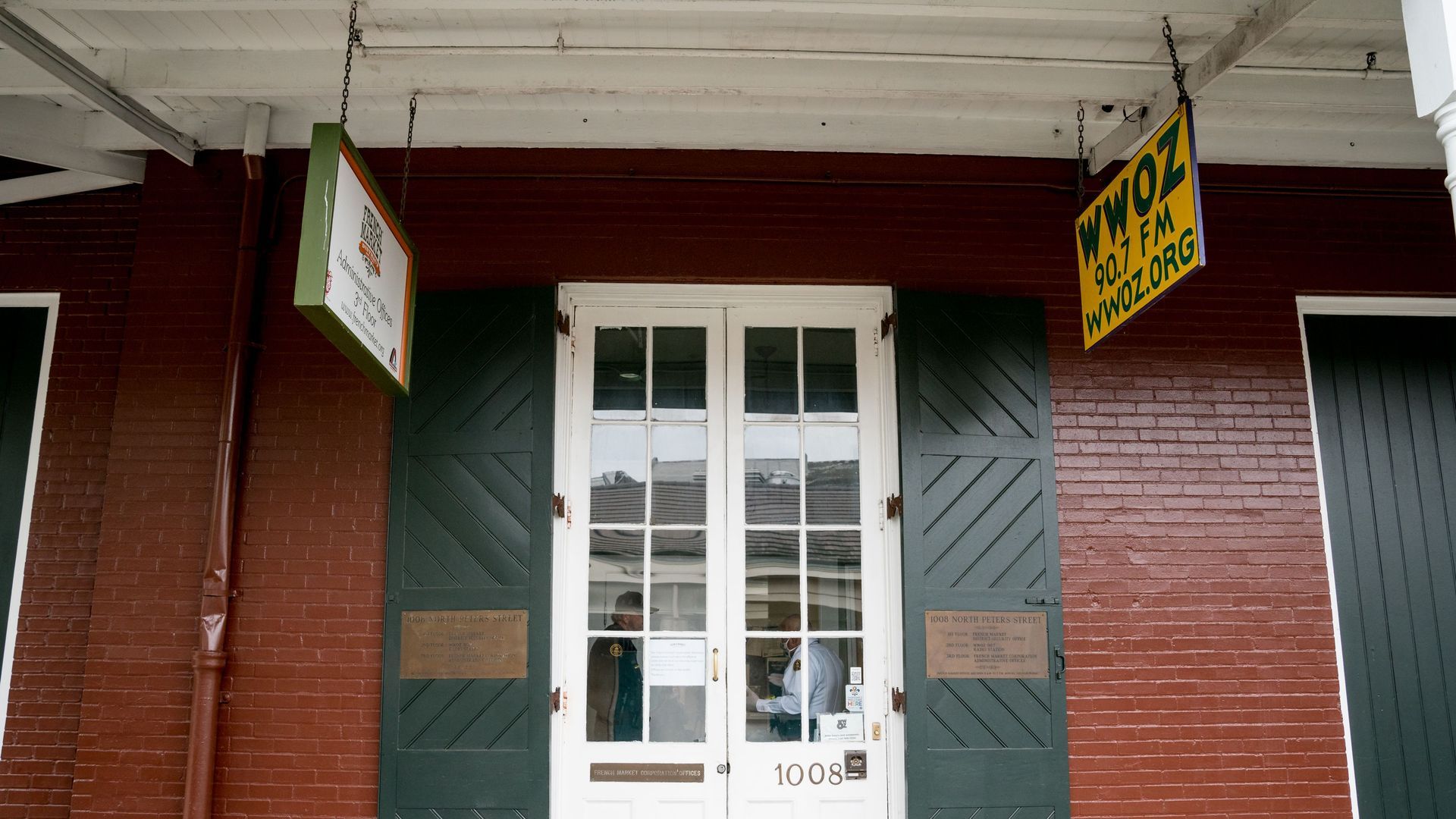 The front door of the WWOZ broadcast studio in the French Market. The WWOZ building sign hangs above the door.