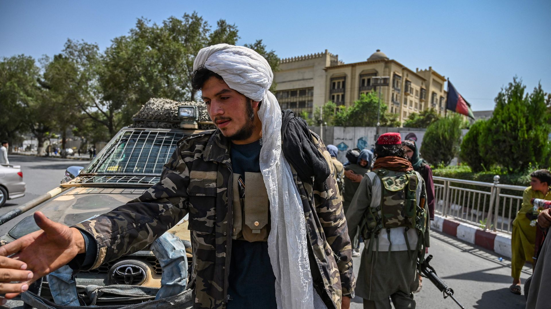 Taliban fighters stand guard along a street at the Massoud Square in Kabul 