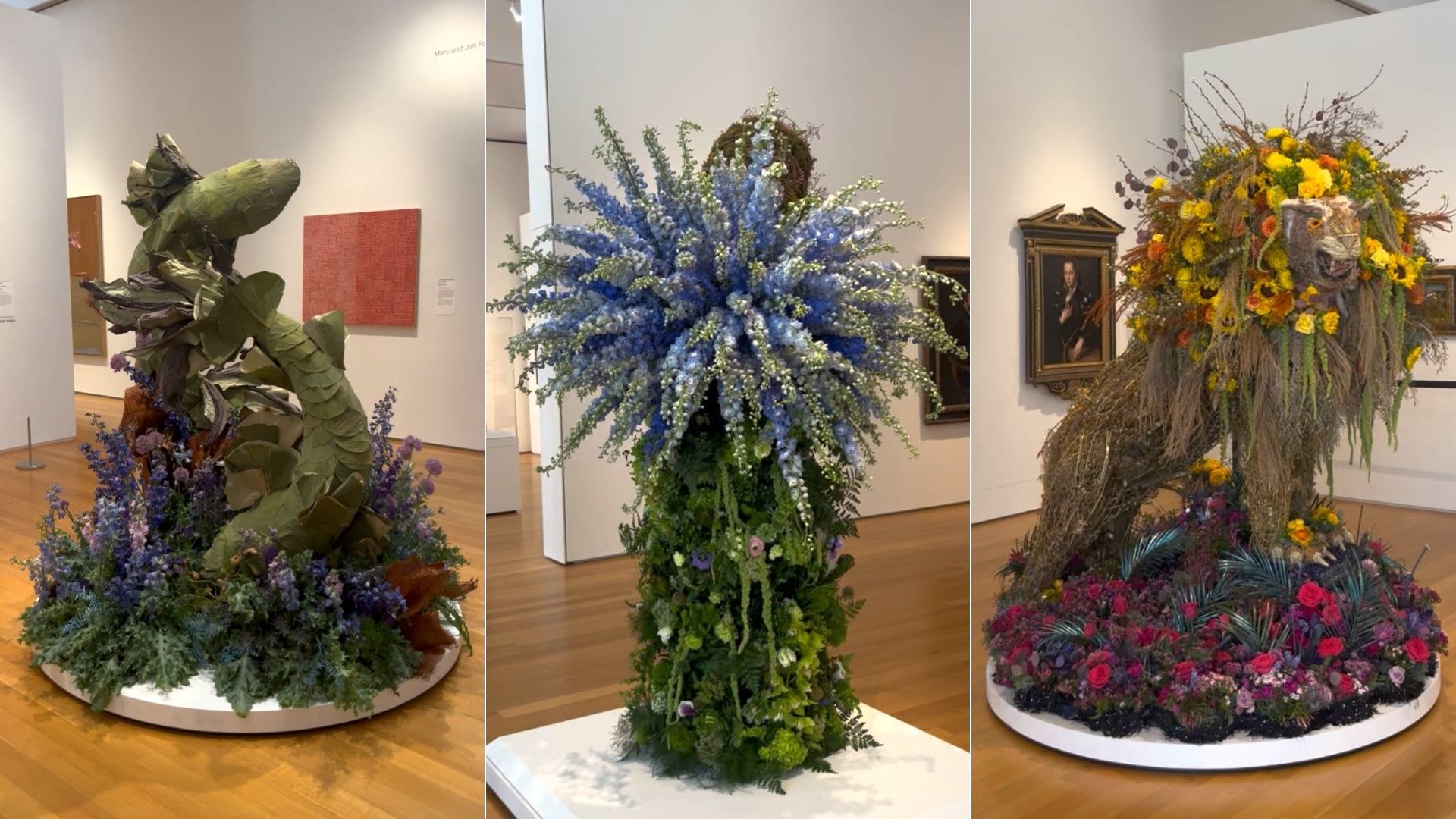 Triptych of gallery floral sculptures: left a large green leafy form with purple blossoms; center a tall blue cascading arrangement; right a yellow-and-grass creature amid colorful flowers.