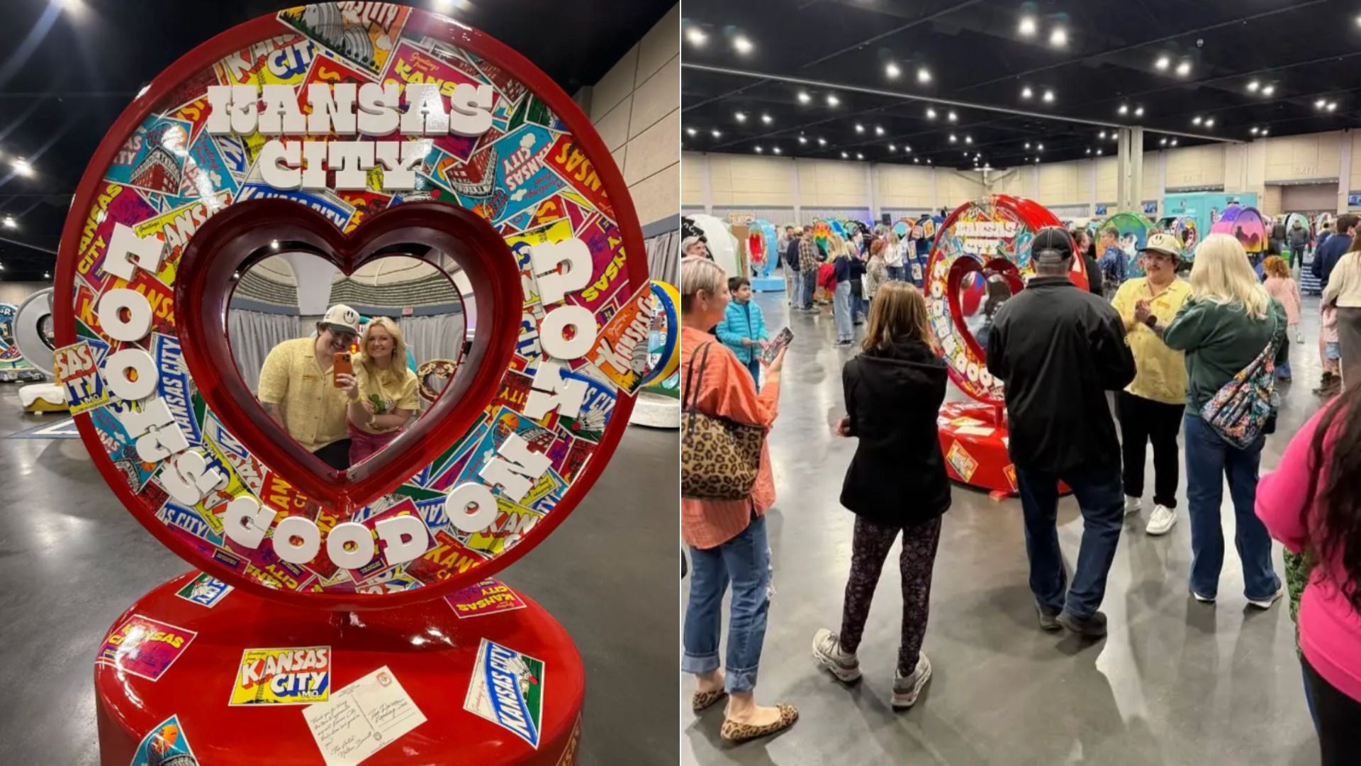 Two people pose for a selfie inside a bright red, heart-shaped frame covered with colorful "Kansas City" stickers at an indoor expo, with more frames and visitors in the background.